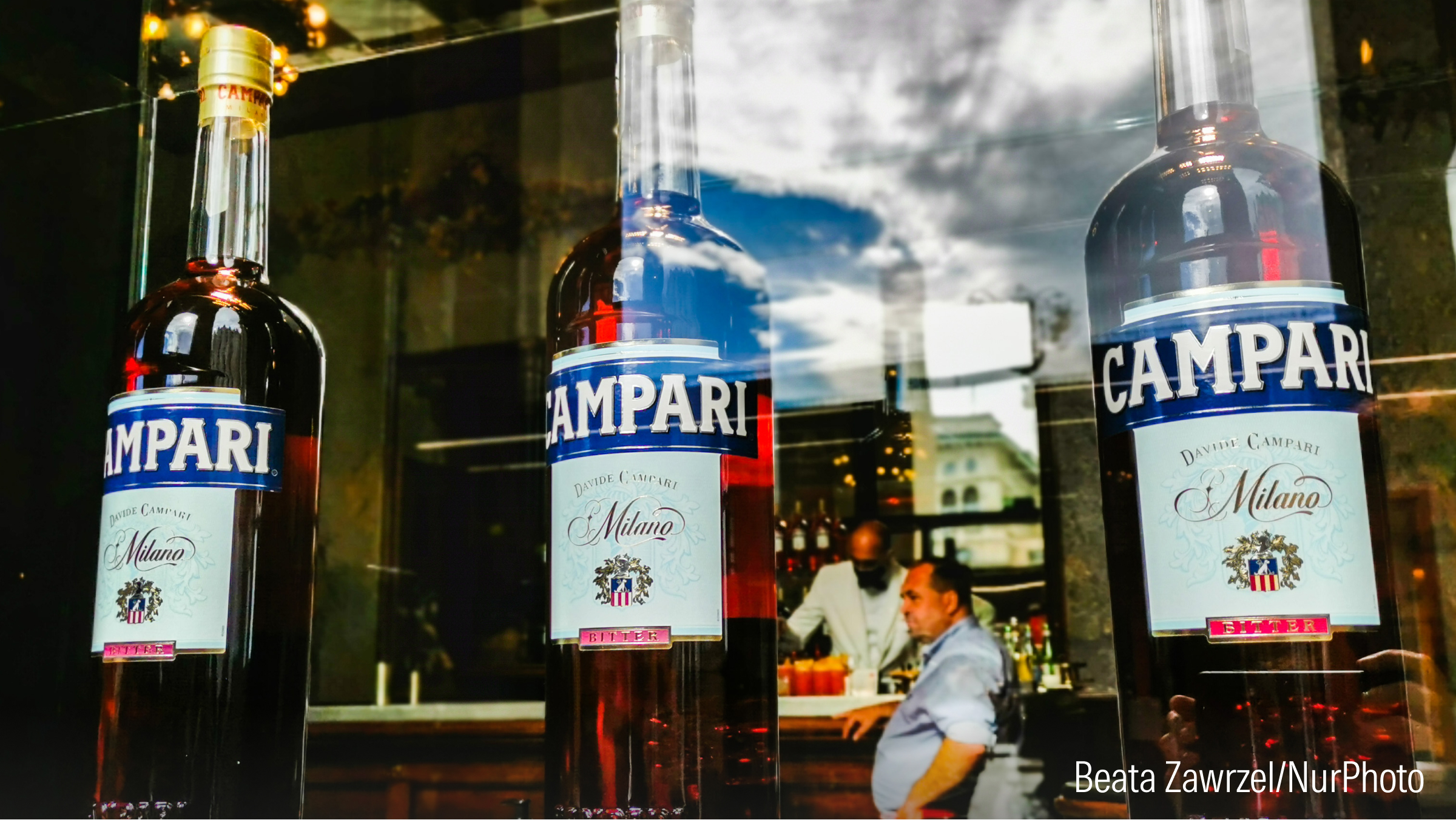 Bottles of Campari are seen in a window.