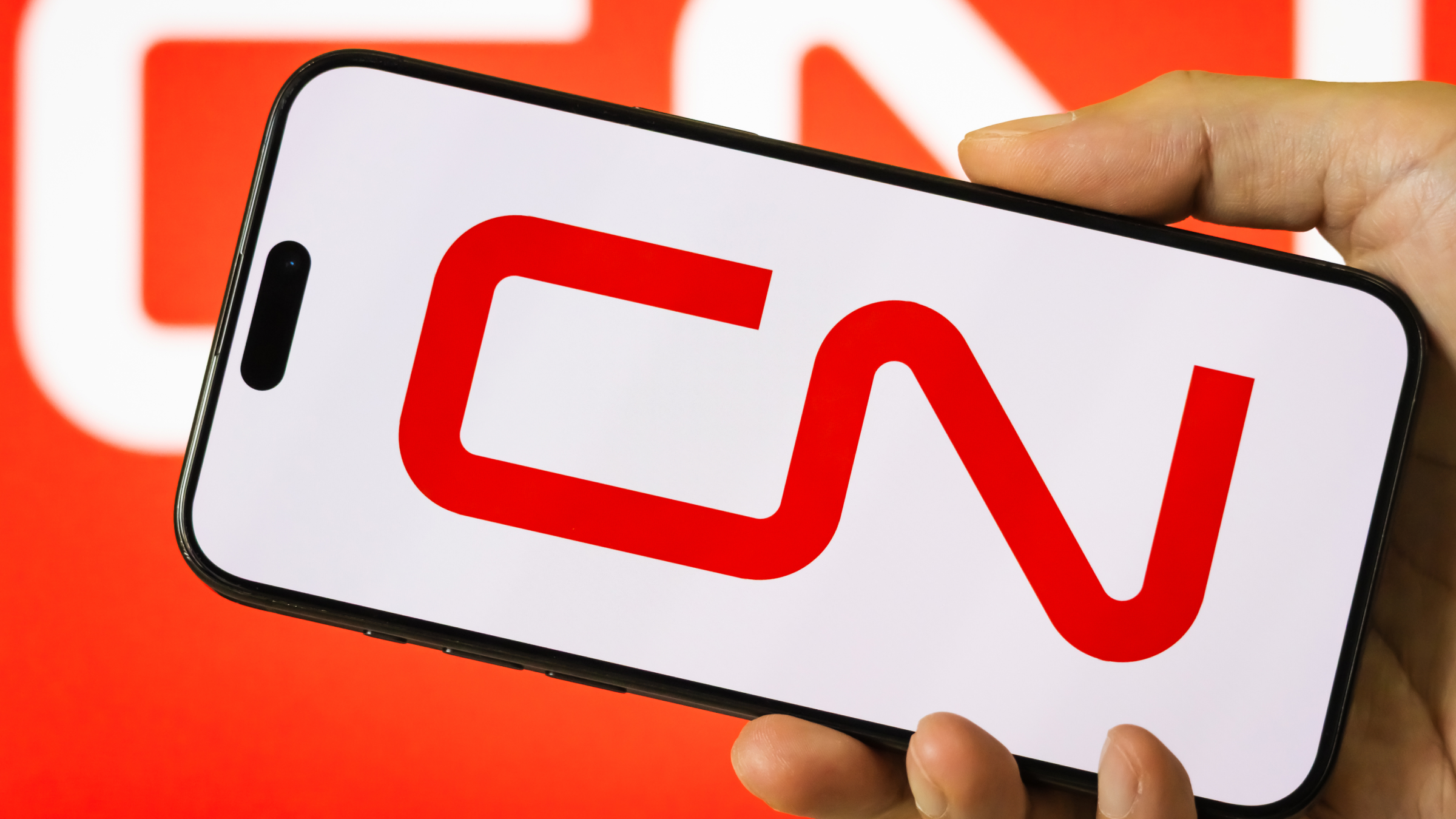 A person holds a smartphone displaying the logo of Canadian National Railway Company.