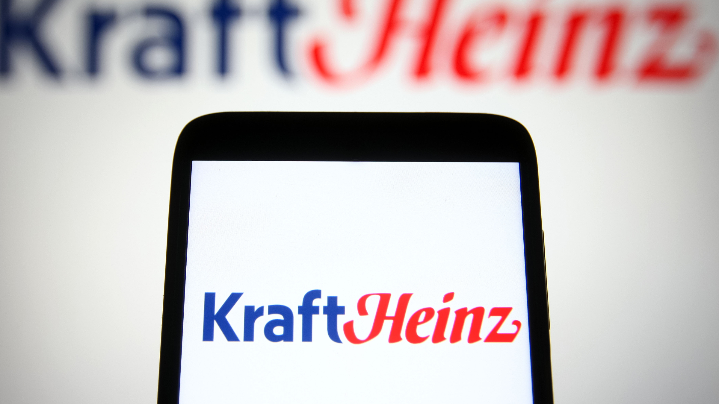 The Kraft Heinz Company (KHC) logo is seen on a smartphone.