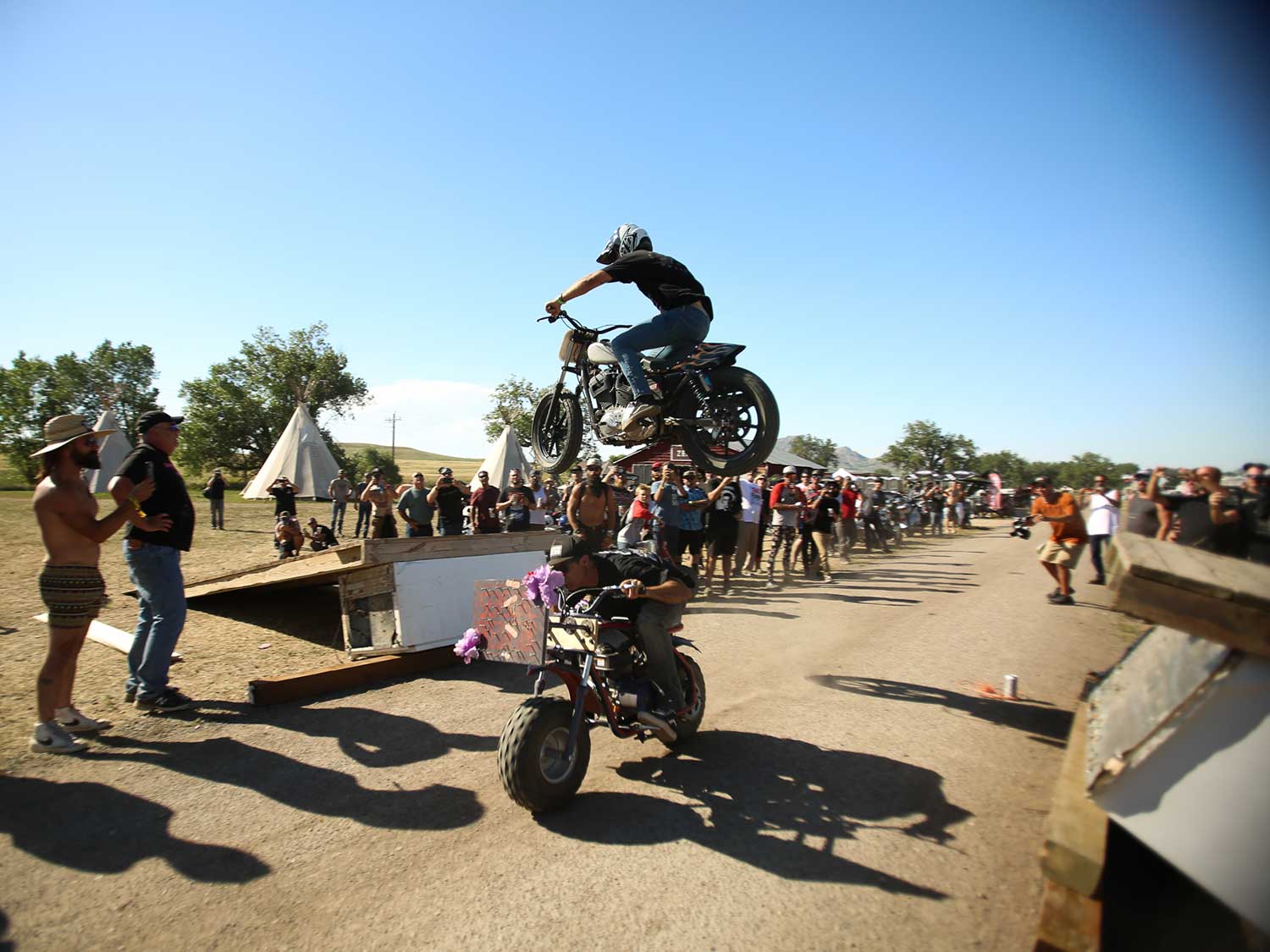 Sportster jumps over a rider on a minibike at Sturgis 2020