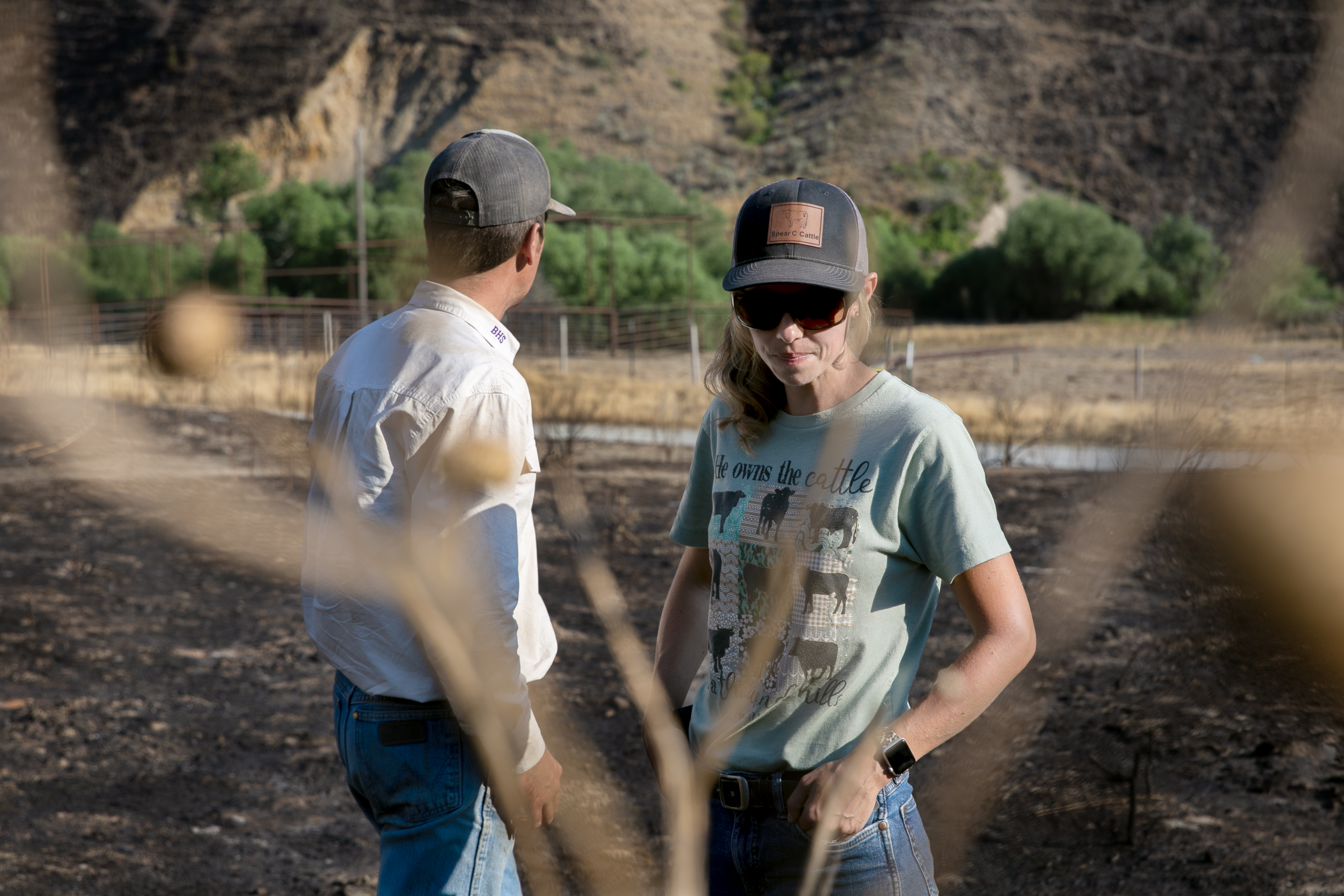 Jared Smull, left, and his wife Amanda stand on burned land at the edge of their rangeland near Durkee, Ore., July 31, 2024. Jared, a fifth generation rancher, says he has never experienced a burn of this scale. He anticipates it will take several years to recover. 