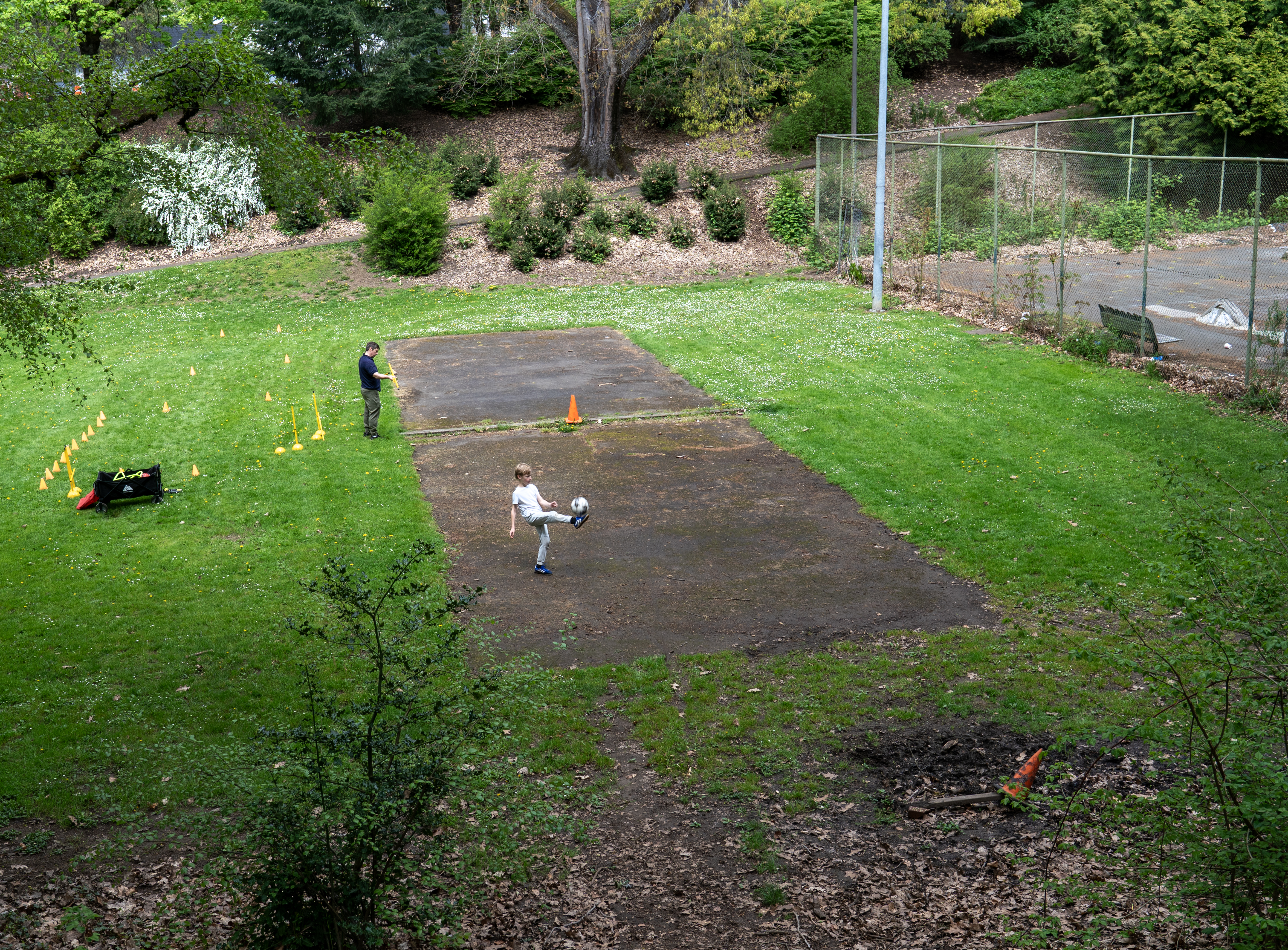 A father and son find a place to play at Creston Park, near the tennis courts, right, April 21, 2025. A new audit details facilities across Portland that are in need of repair.
