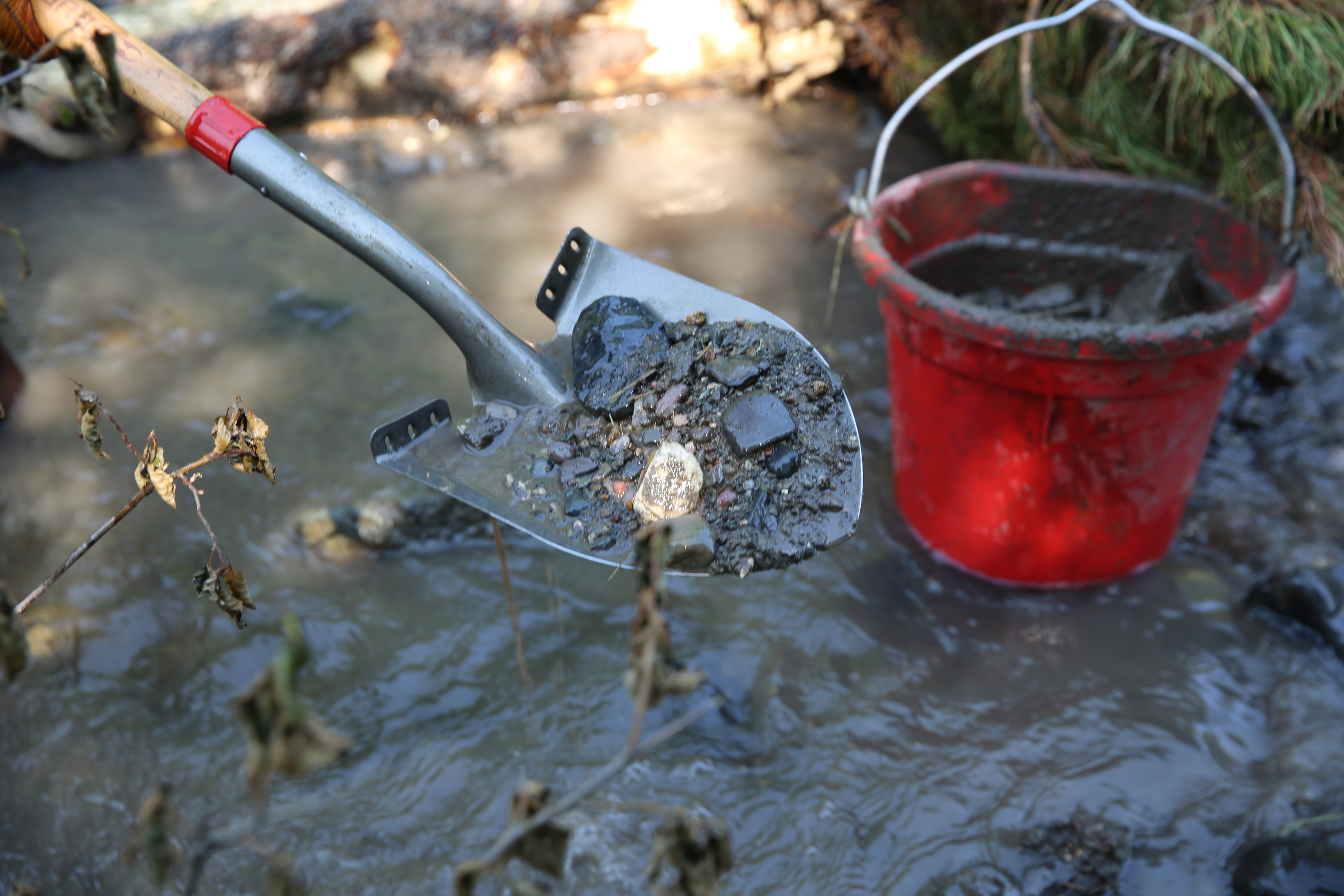 Crews use shovels full of river rock to stabilize new beaver dam analogues along Sheep Creek.