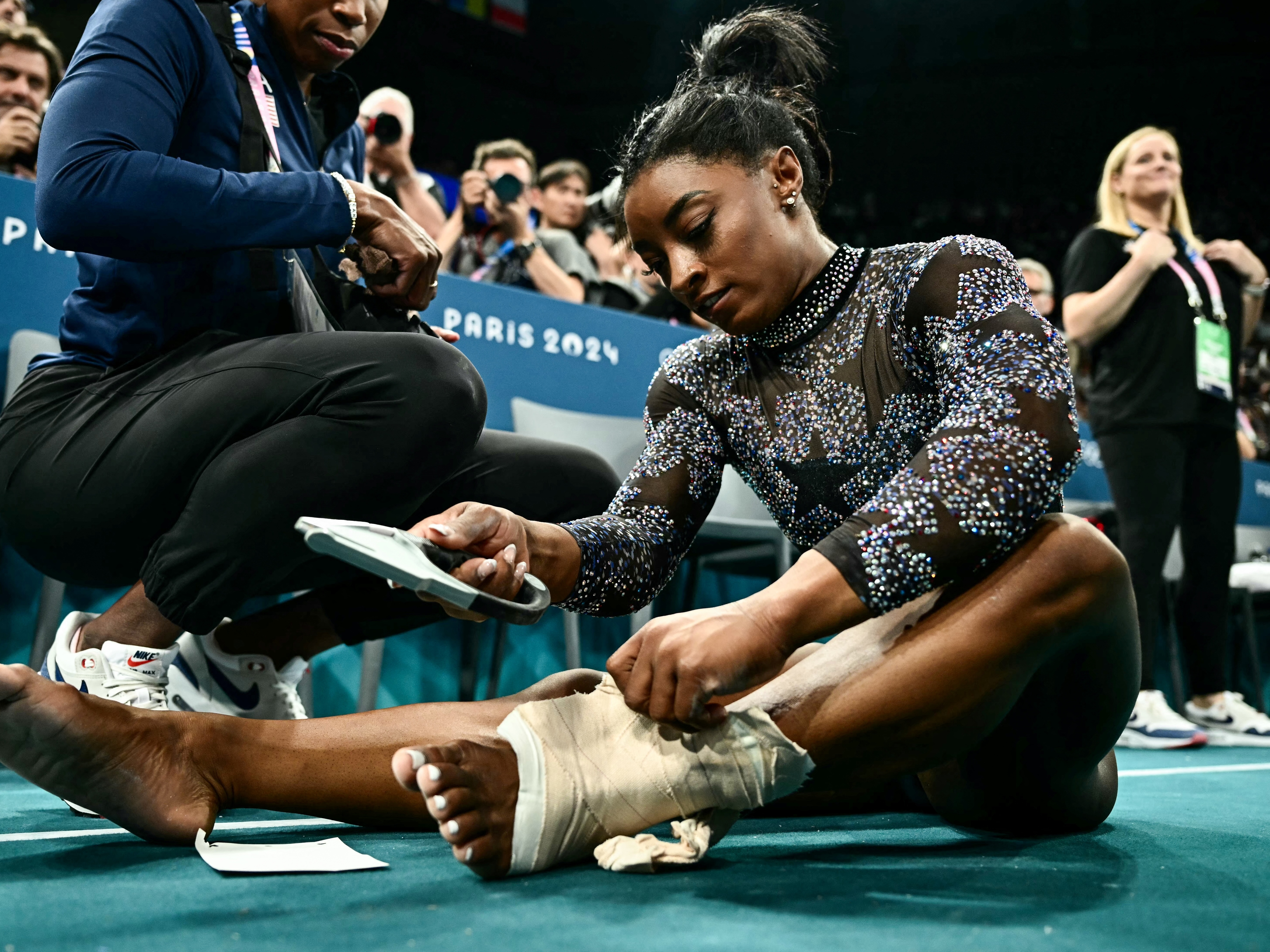 The U.S. gymnast Simone Biles appeared to hurt her lower left leg during a warmup on Sunday, but she finished the remaining events after wrapping her ankle with thick athletic tape. 