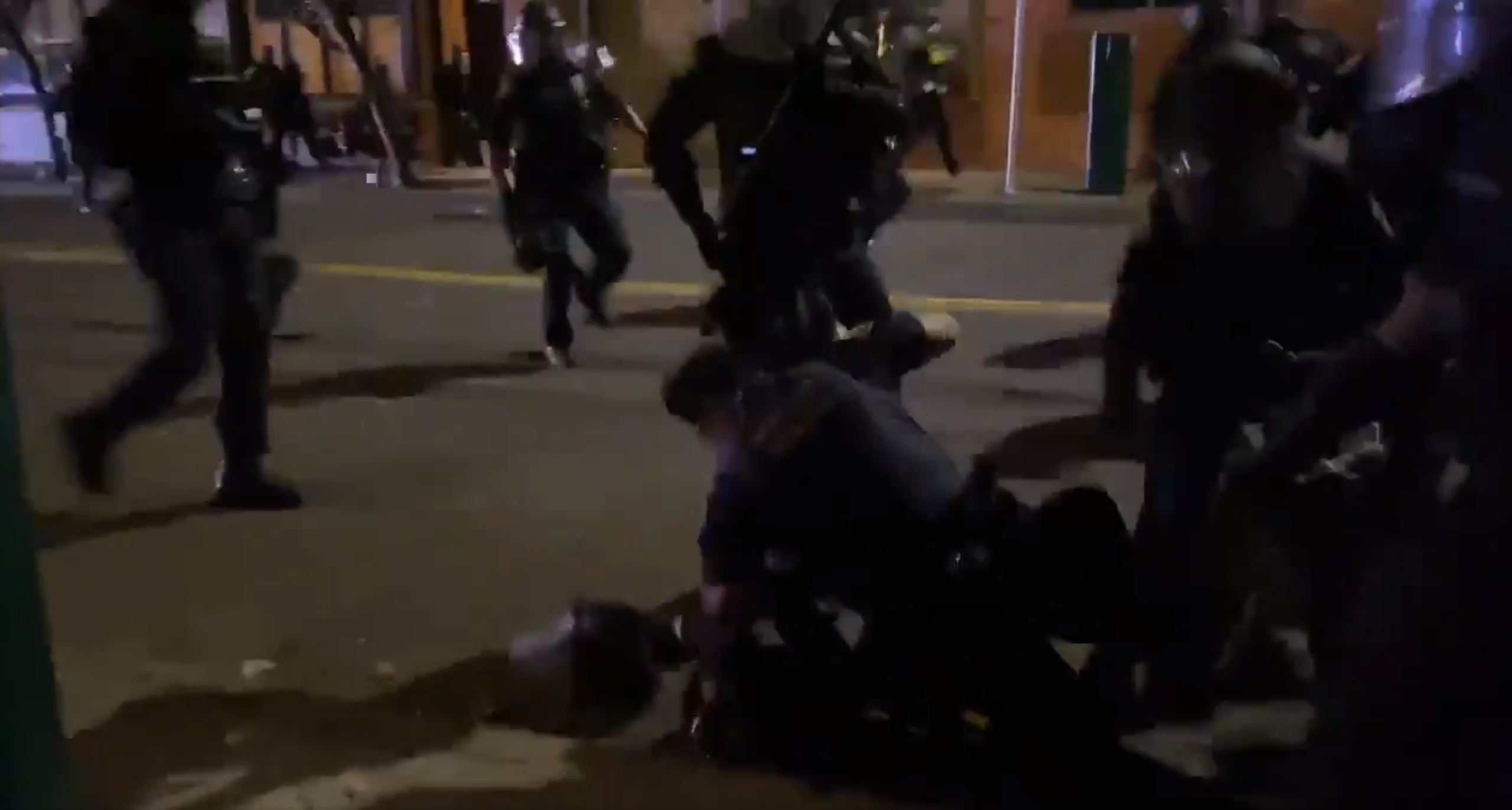 A Portland police officer punches a protester after throwing them to the ground while dispersing a demonstration Monday, Aug. 31, 2020, in Portland, Ore.