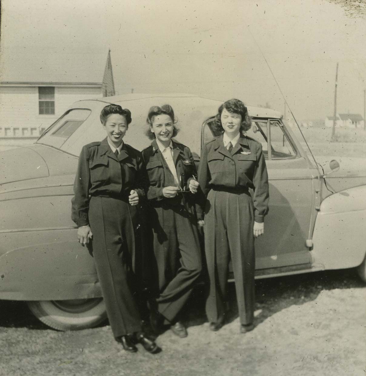 Hazel Ying Lee, left, wears her WASP uniform and stands with her comrades in front of a car, around 1943.