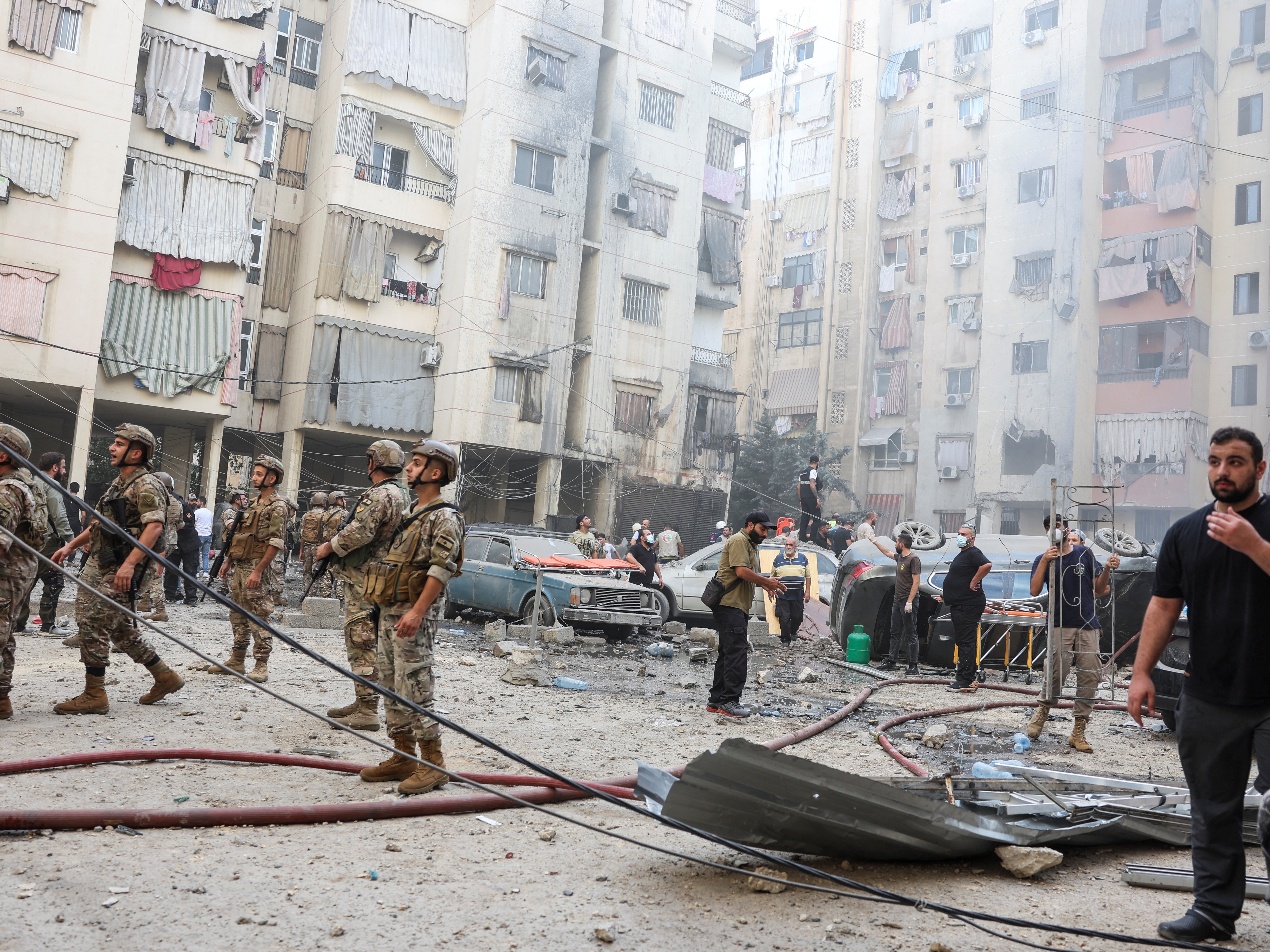 People and members of the military inspect the site of an Israeli strike in the southern suburbs of Beirut, Lebanon, on Friday.