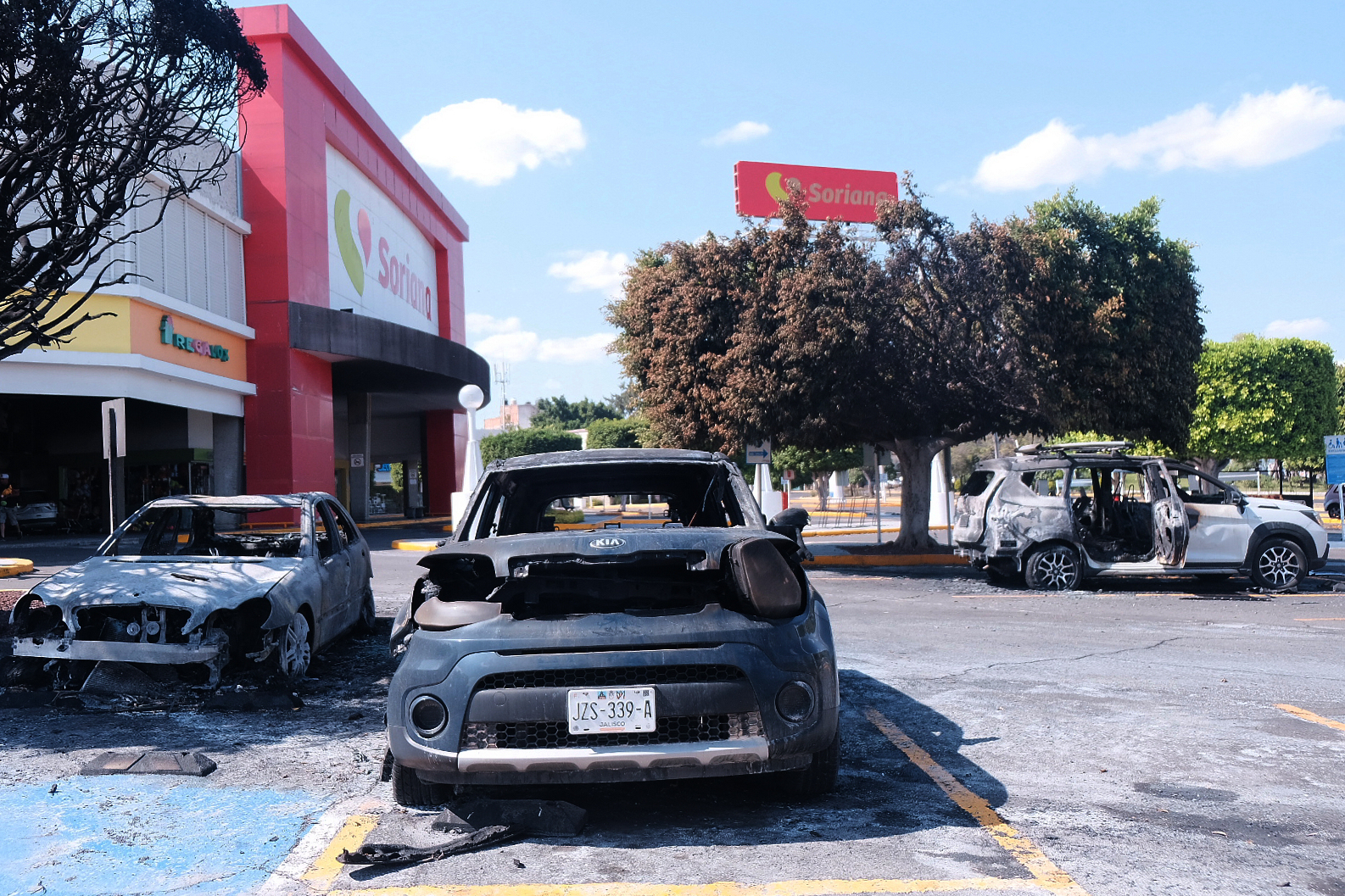 Charred vehicles sit in a parking lot sit outside a shopping mall in Guadalajara, Jalisco state, Mexico, Sunday, Feb. 22, 2026, as authorities reported the Mexican Army killed Jalisco New Generation Cartel leader Nemesio Oseguera, known as "El Mencho."