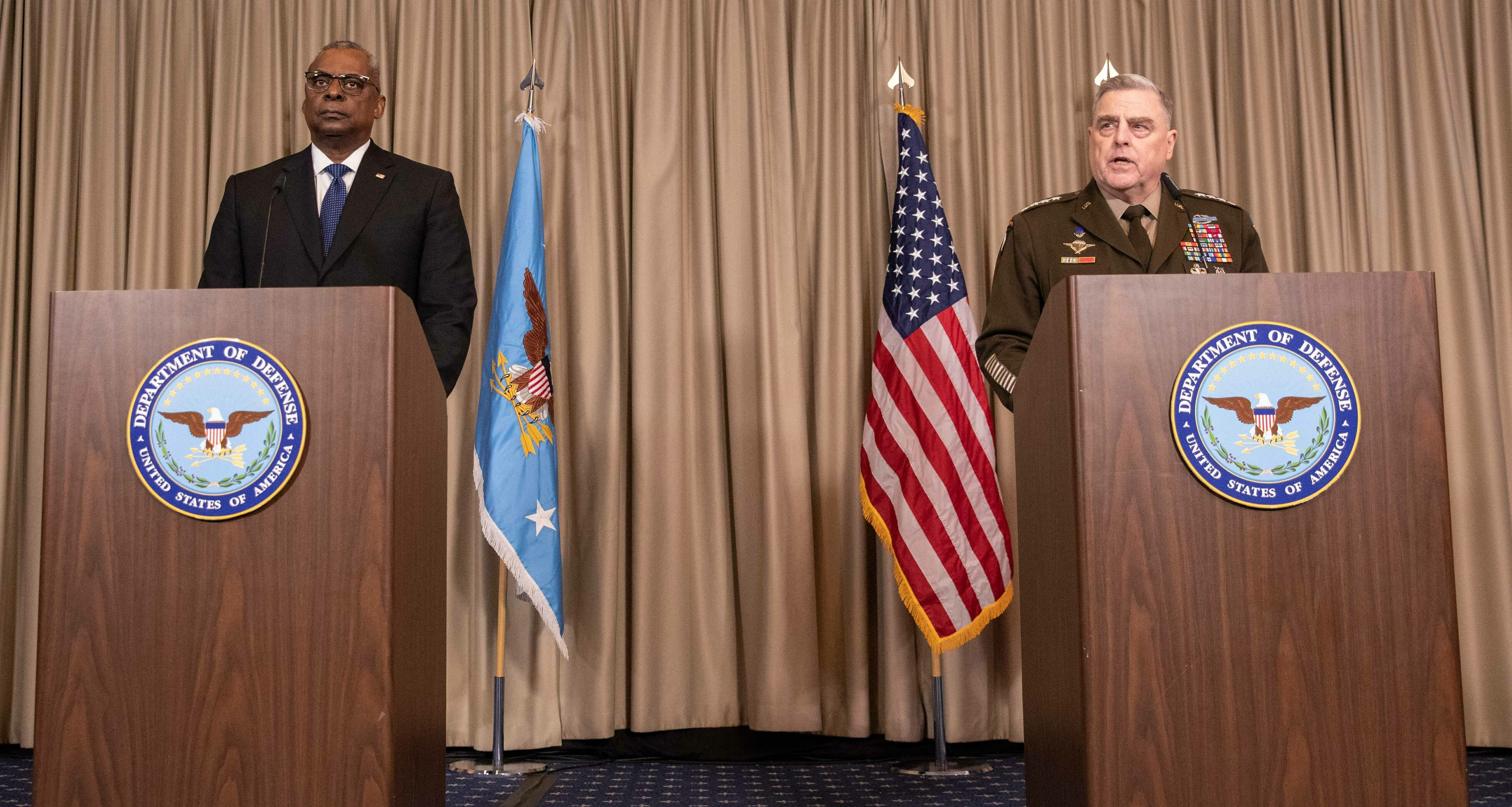 U.S. Defense Secretary Lloyd Austin (left) and the chairman of the Joint Chiefs of Staff, Gen. Mark Milley, discuss details of a huge U.S. and NATO arms package for Ukraine at the U.S. air base in Ramstein, Germany, on Friday.