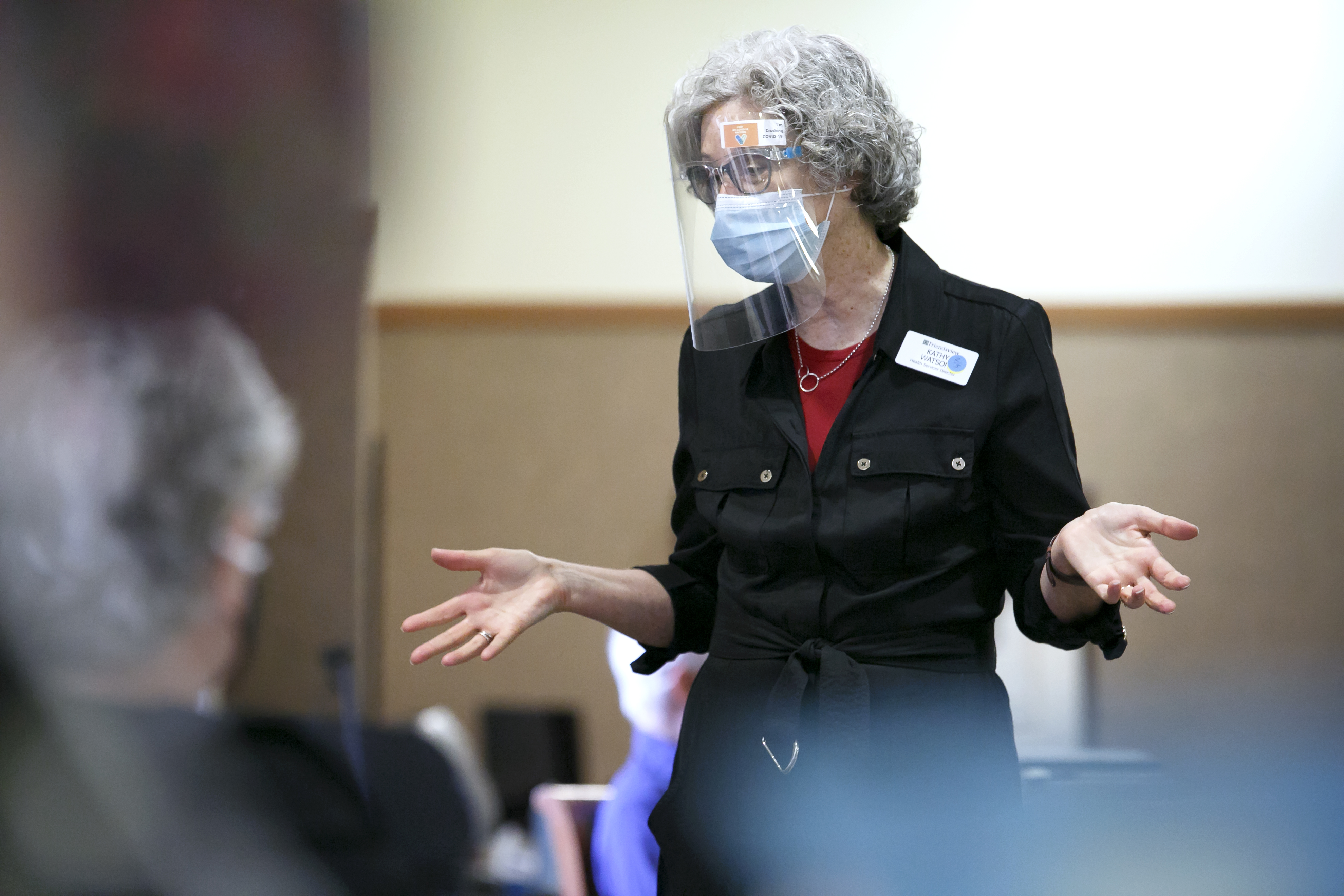Kathy Watson, director of health services at Friendsview Retirement Community in Newberg, Ore., talks with residents in the observation area during a COVID-19 vaccination clinic on Feb. 5, 2021. 