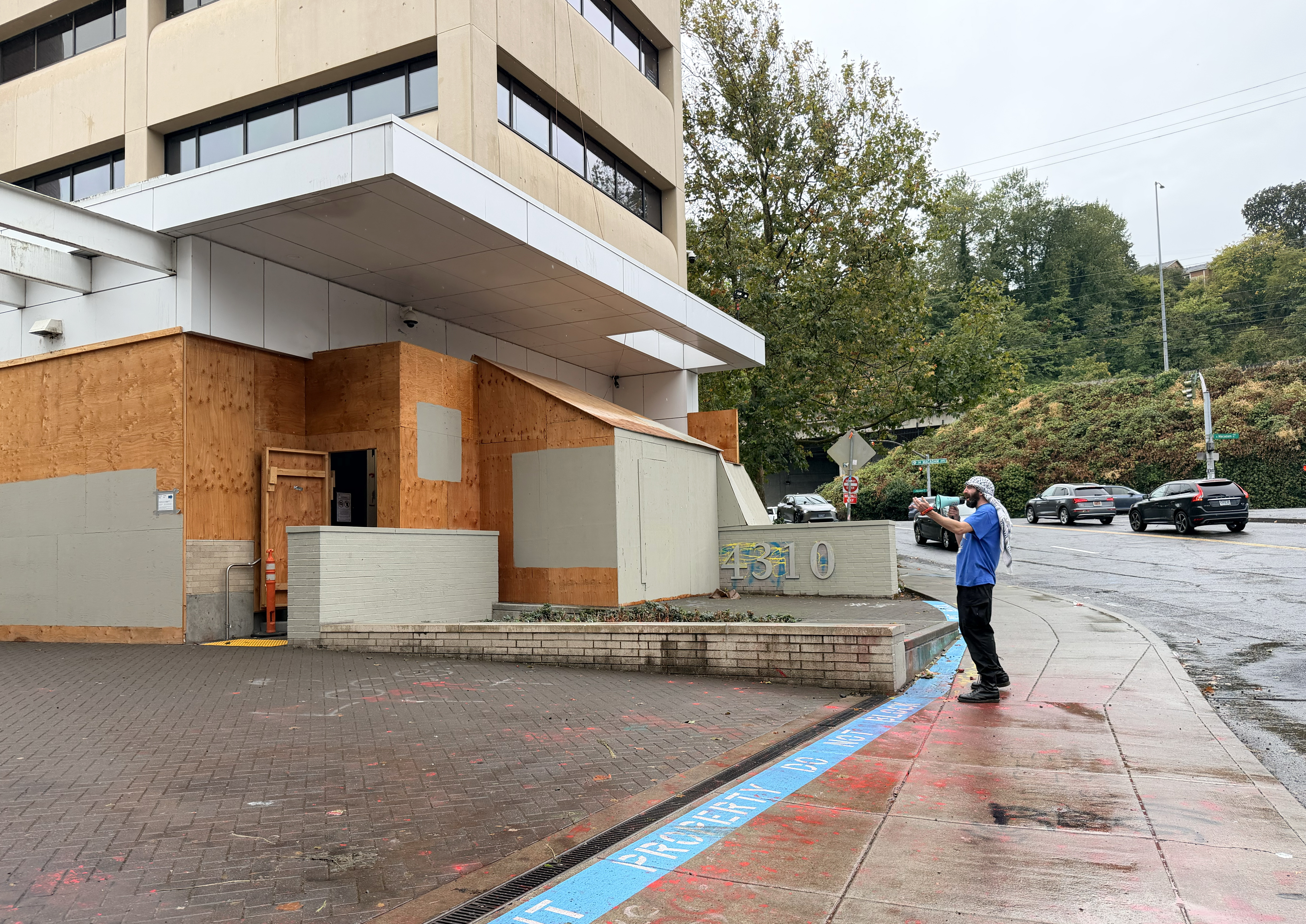 A lone protester with a megaphone outside of the U.S. Immigration and Customs Enforcement facility in Portland, Ore., Oct. 1, 2025.