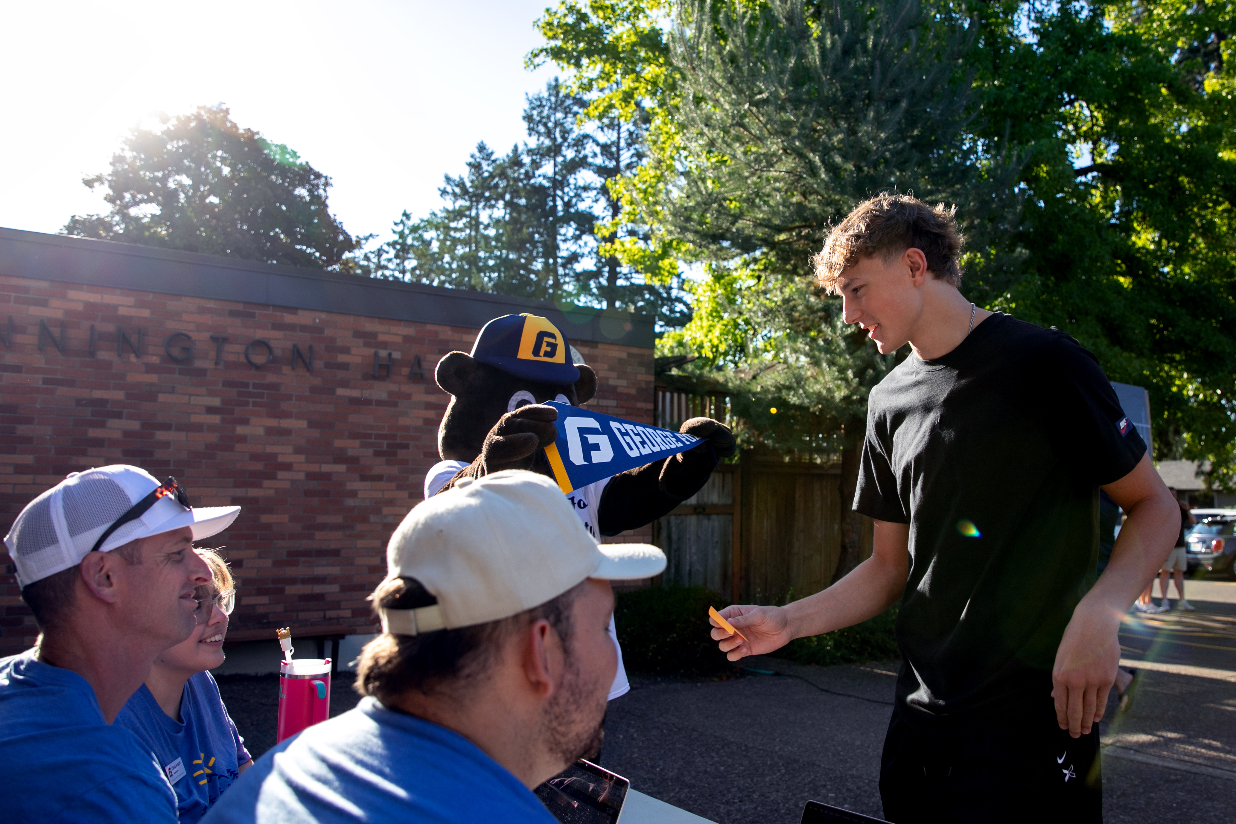 Incoming freshman Rylan Nelson receives a school pennant and keys as he moves into the dorms at George Fox University in Newberg, Ore., Aug. 22, 2025. The university is looking at another record high enrollment for the 2025-2026 school year, living up to their title as the largest private university in Oregon. 