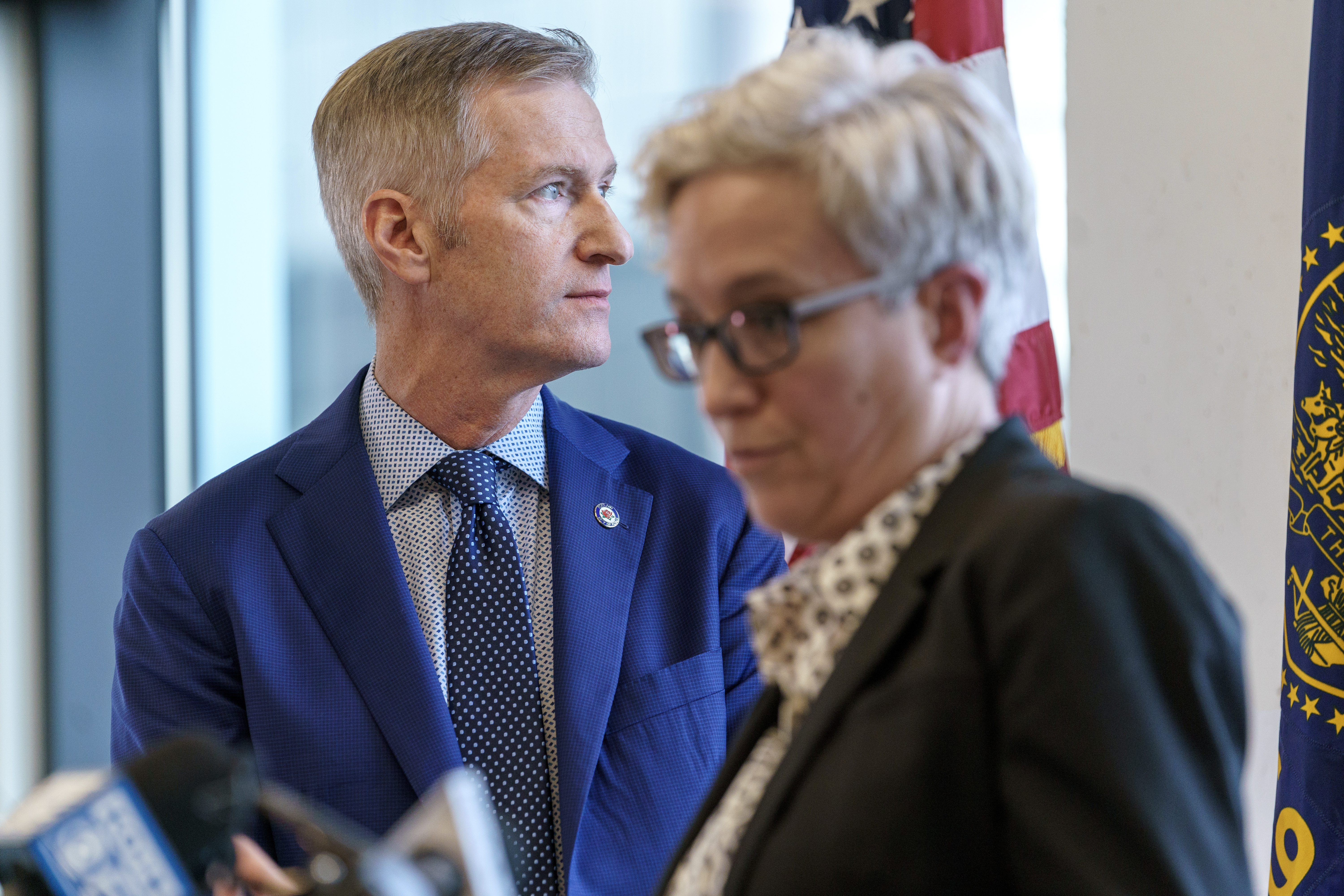 FILE: Portland Mayor Ted Wheeler, left, looks out a window as Gov. Tina Kotek speaks at a press conference in Portland, Jan. 30, 2024, where a 90-day state of emergency was declared to address the fentanyl crisis in Portland. 