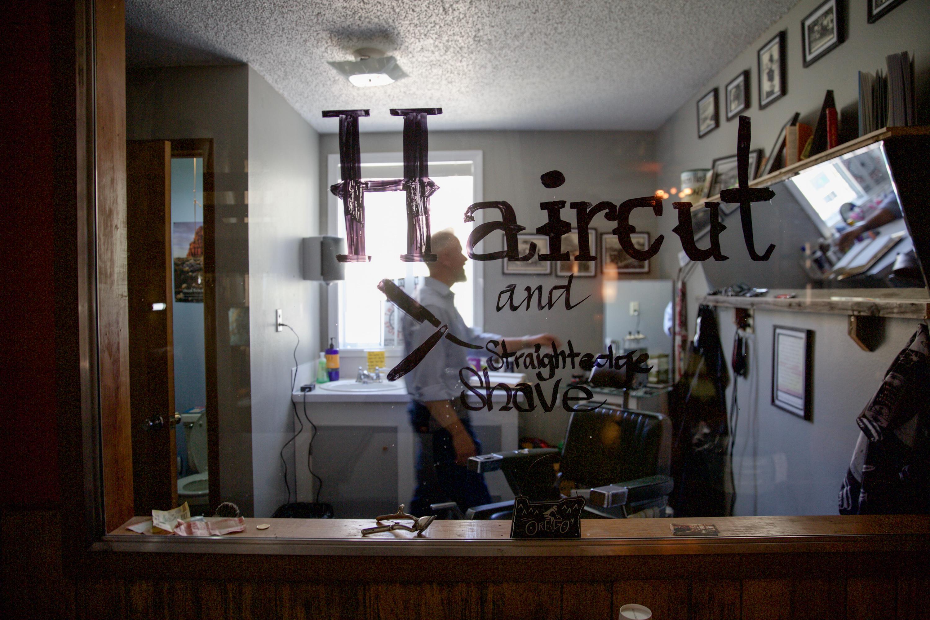 Mayor Patrick Farrell tidies up his barber shop in Mitchell, Ore., Monday, June 3, 2019. Along with being the small town's mayor, Farrell is a school bus driver, barber, hostel owner and pastor.