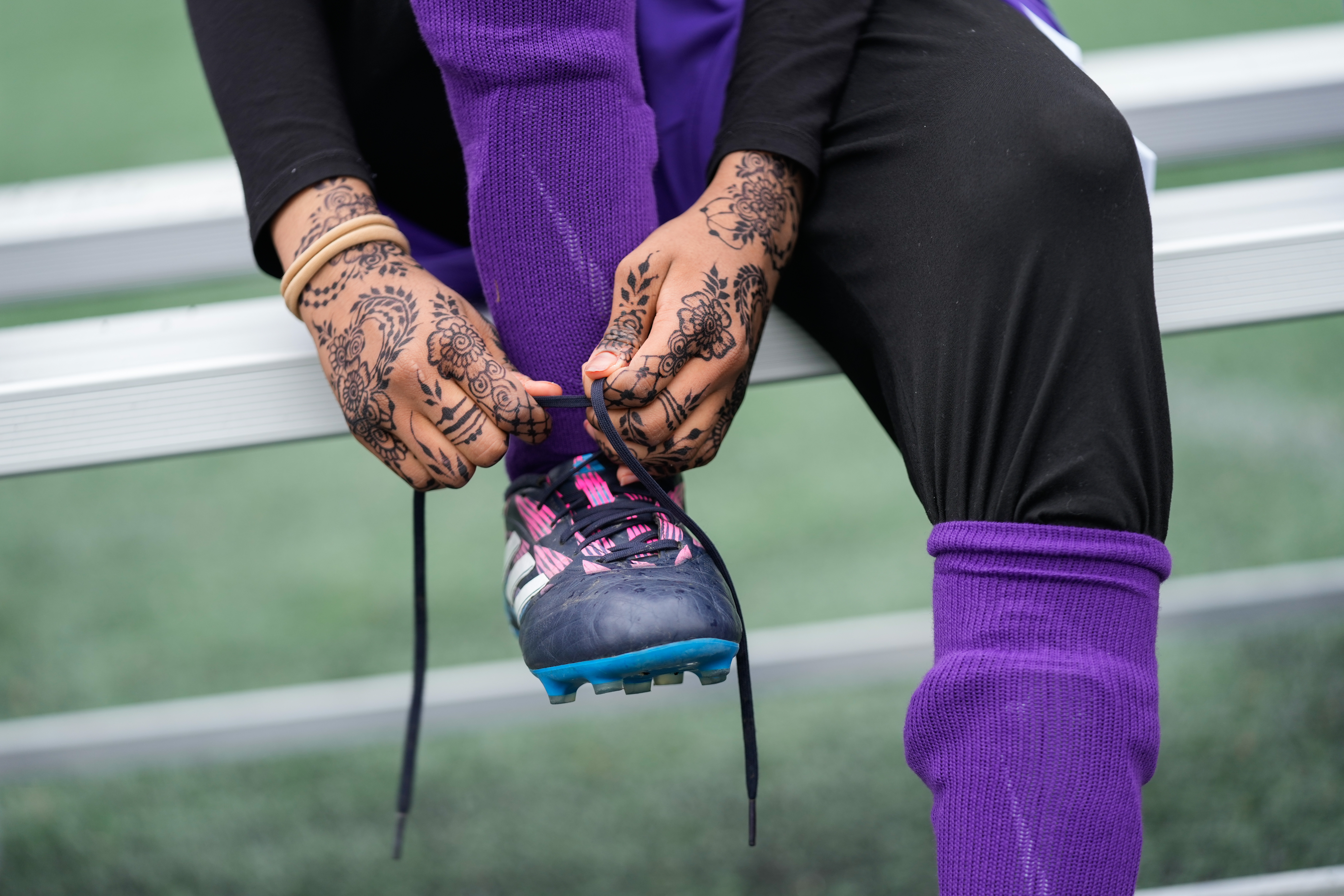 FILE - Amina Mohamed laces up her cleats during a soccer tournament for immigrant and refugee girls on Sunday, March 29, 2026, in Portland, Ore.