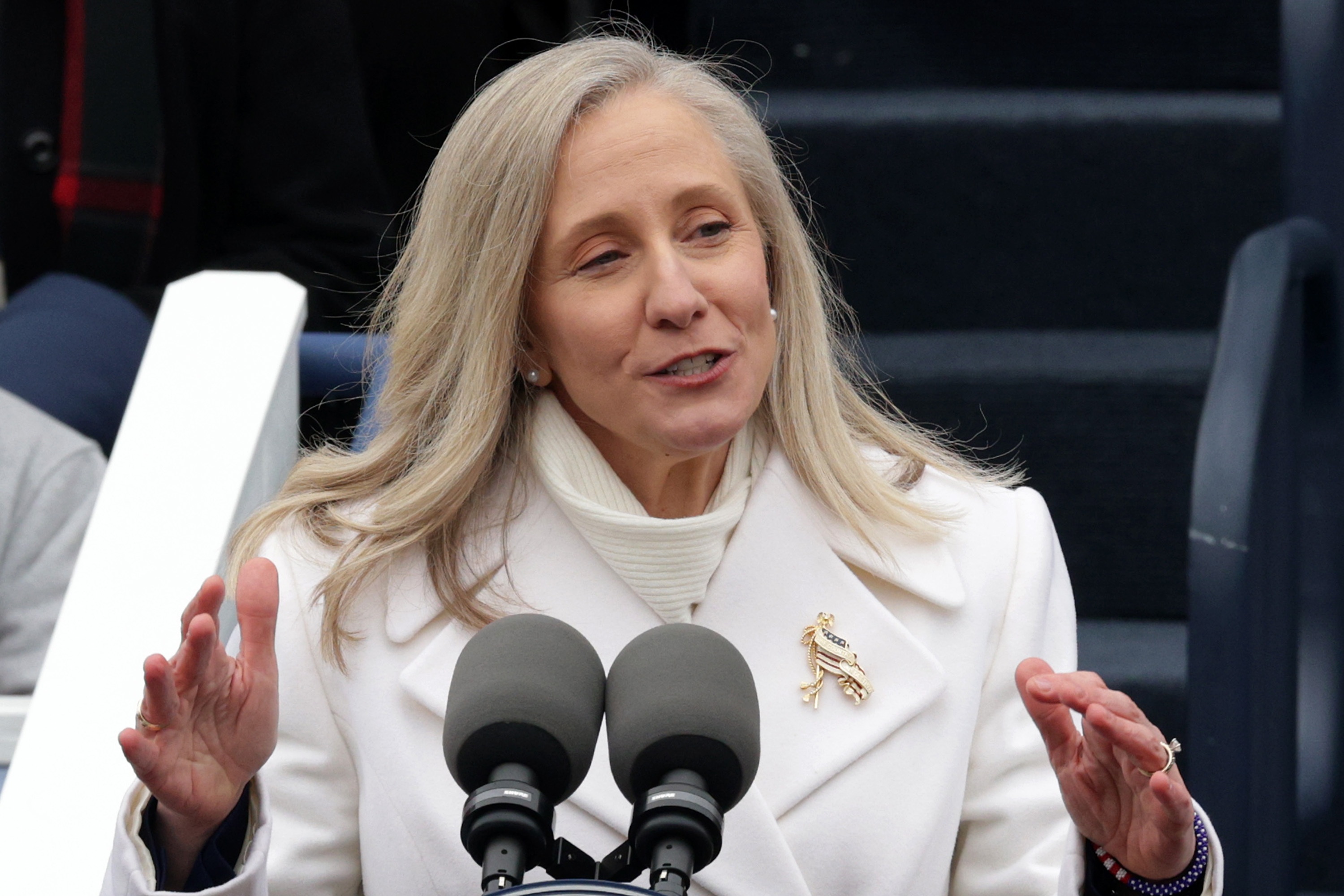 Virginia Governor Abigail Spanberger stands at a pair of microphones.