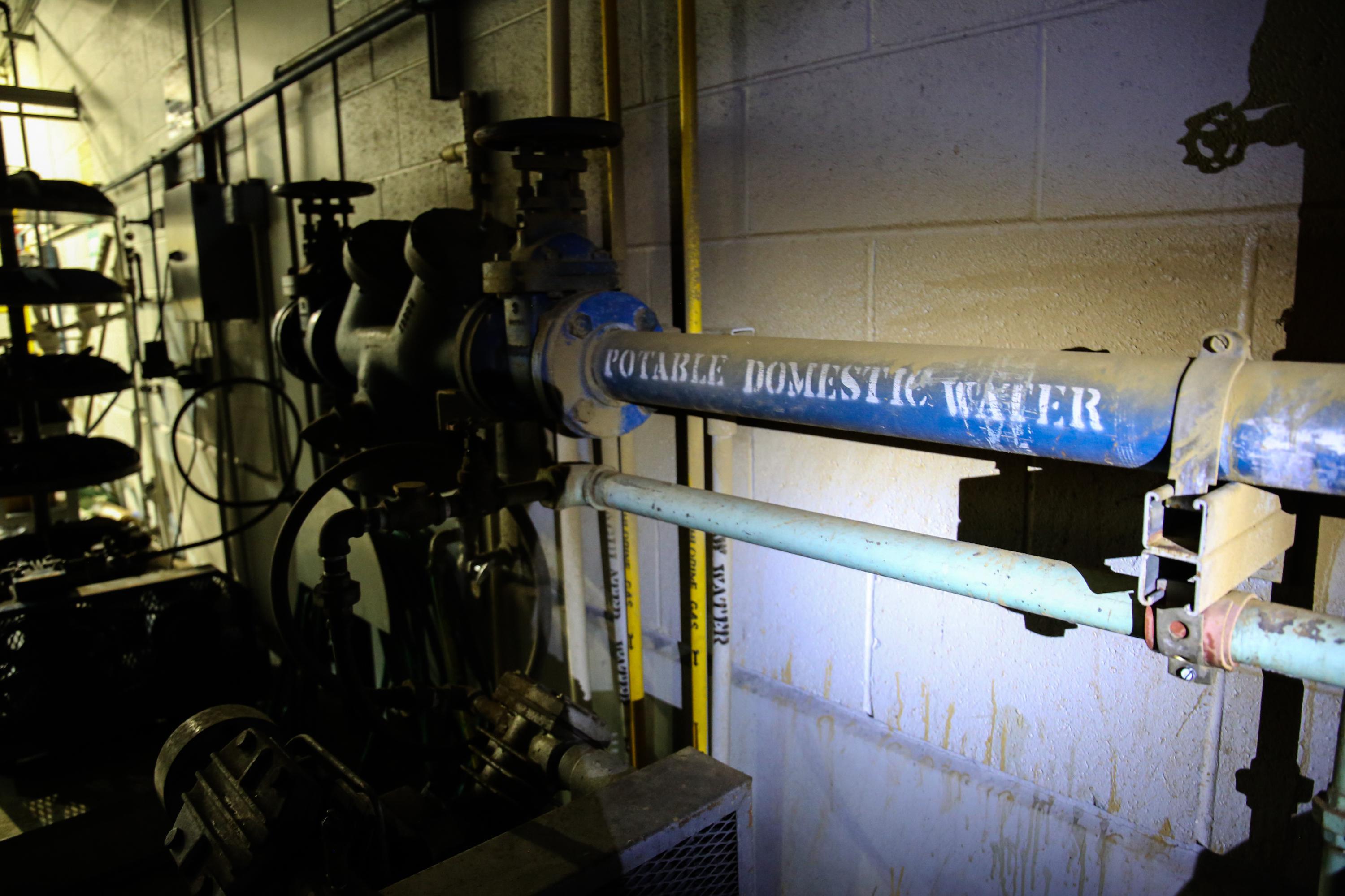 A flashlight beam illuminates a room at the Warm Springs water treatment plant after a power surge in Warm Springs, Ore., Friday, March 29, 2019.