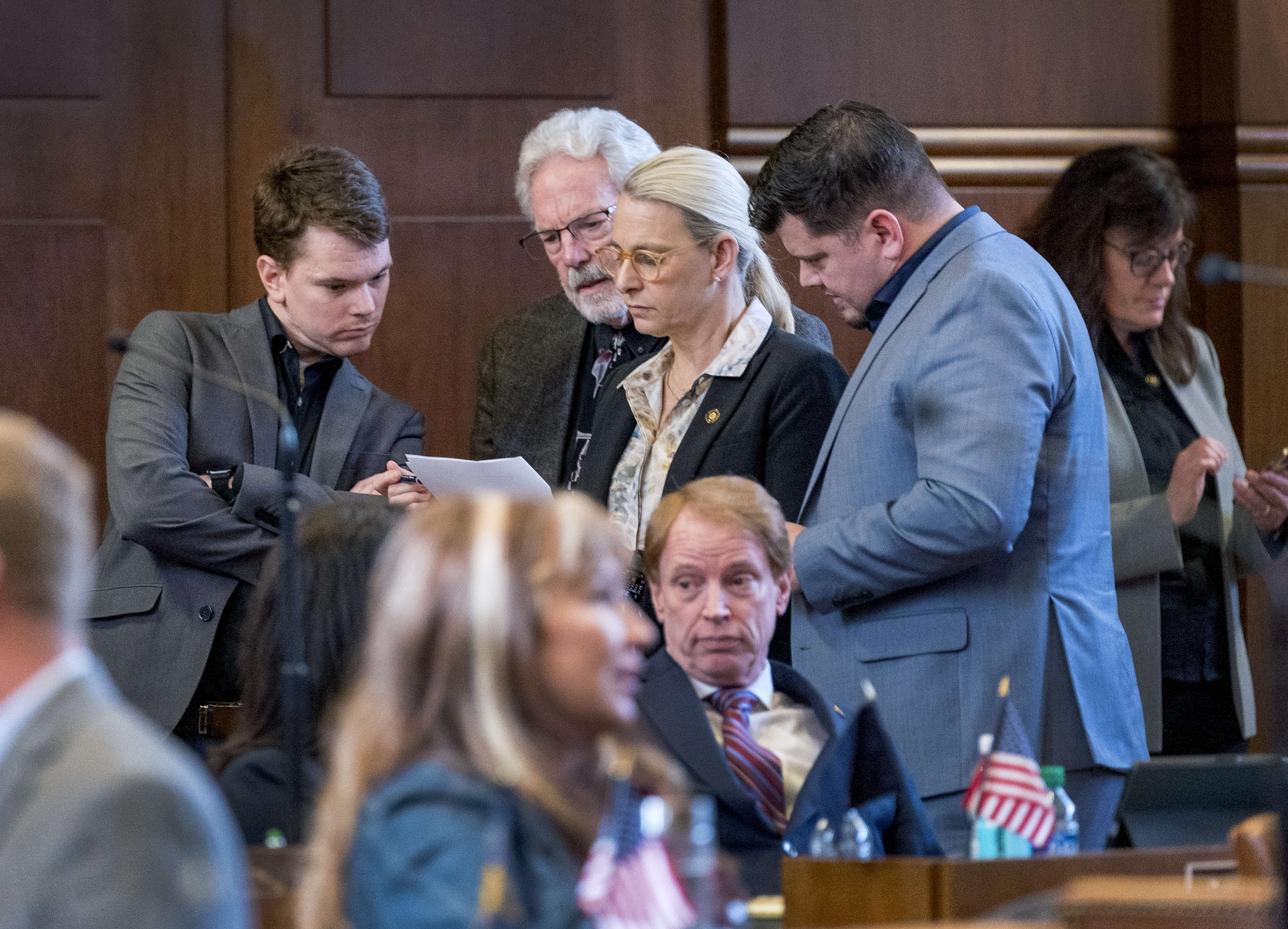 Members of the Oregon Senate talk on the Senate floor Friday at the Capitol in Salem, Ore. The Senate approved House Bill 4002, which passed yesterday in the House. Sen. Kate Lieber (center, standing) a Democrat from Portland, was one of the architects of the bill. Sen. Tim Knopp (seated in front of Lieber), a Republican from Bend and the Minority Leader, said the bipartisan bill was a response to the will of Oregonians.