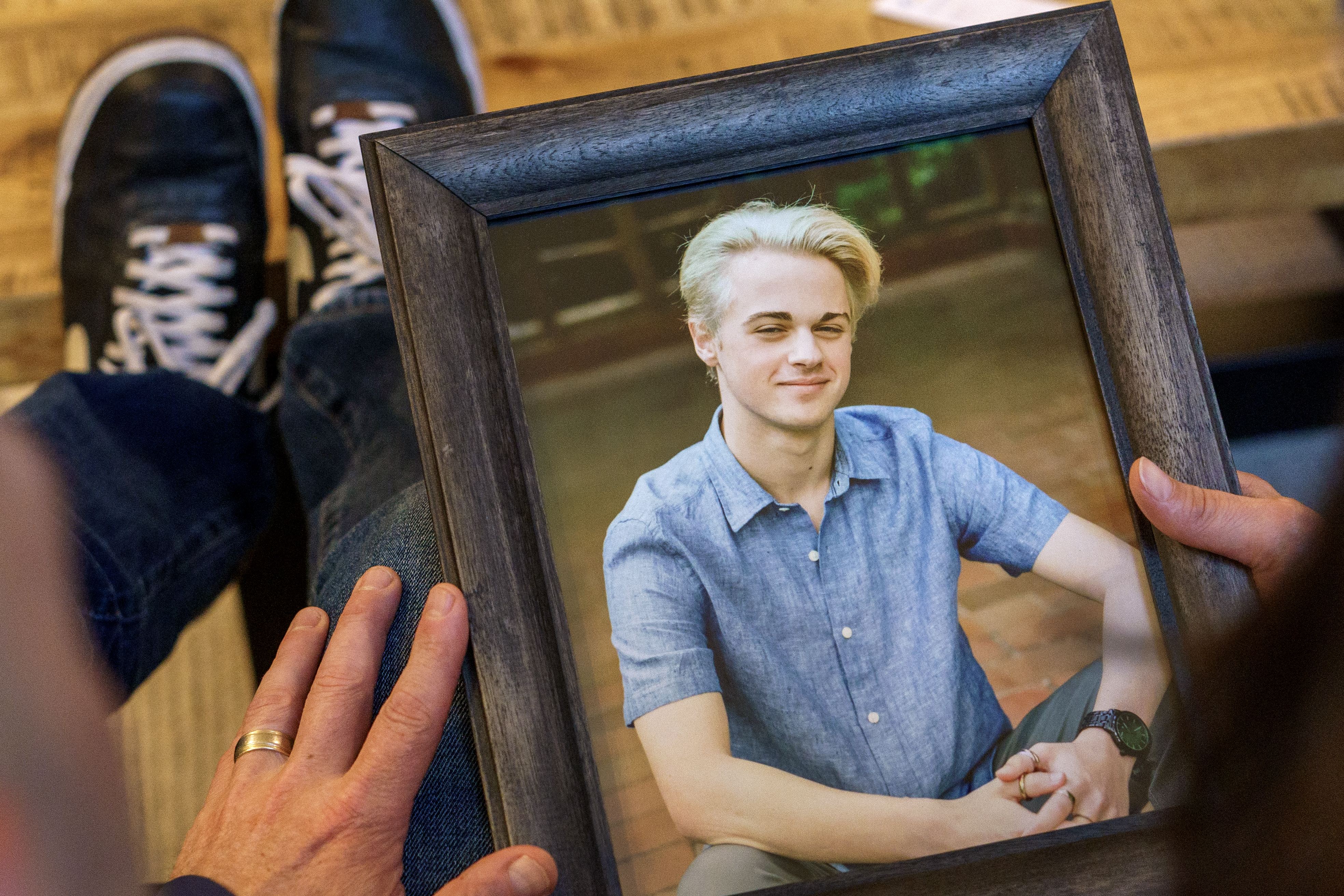 (Out of frame, left to right) Jon and Jennifer Epstein, with a photo of their son Cal at their Beaverton home, May 8, 2023. Cal died in 2020 from a fentanyl overdose after unknowingly taking a pill made with illicit fentanyl. They now share Cal’s story to help spread awareness, including advocating for school districts to teach lessons about the dangers of the drug. 