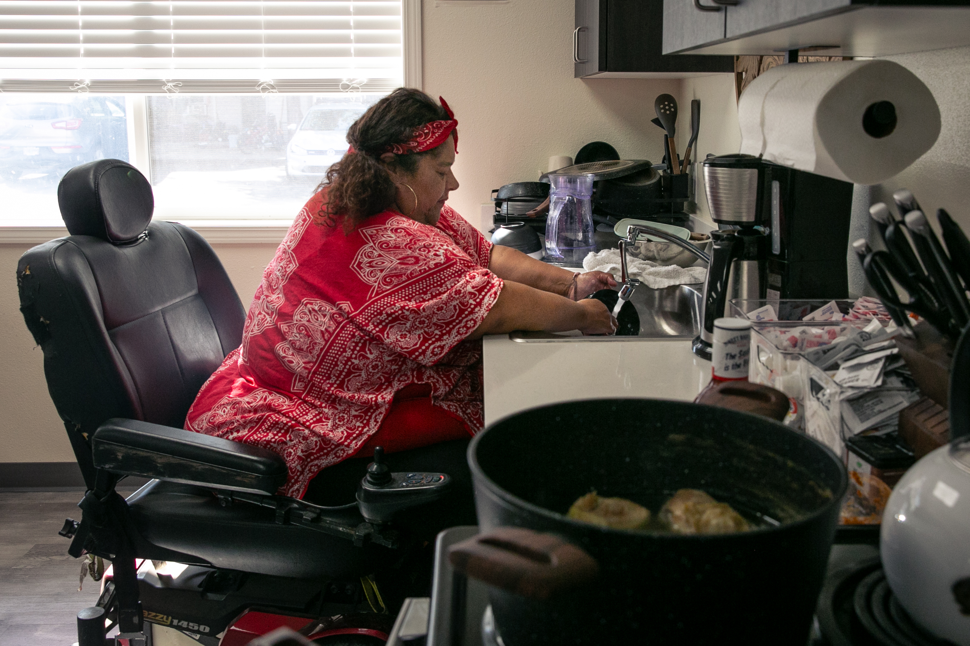 Angelita Amaya washes dishes at the homeless shelter where she resides in Monmouth. Amaya, 56, moved into the shelter where she lives alongside her adult son after financial challenges led her to homelessness.