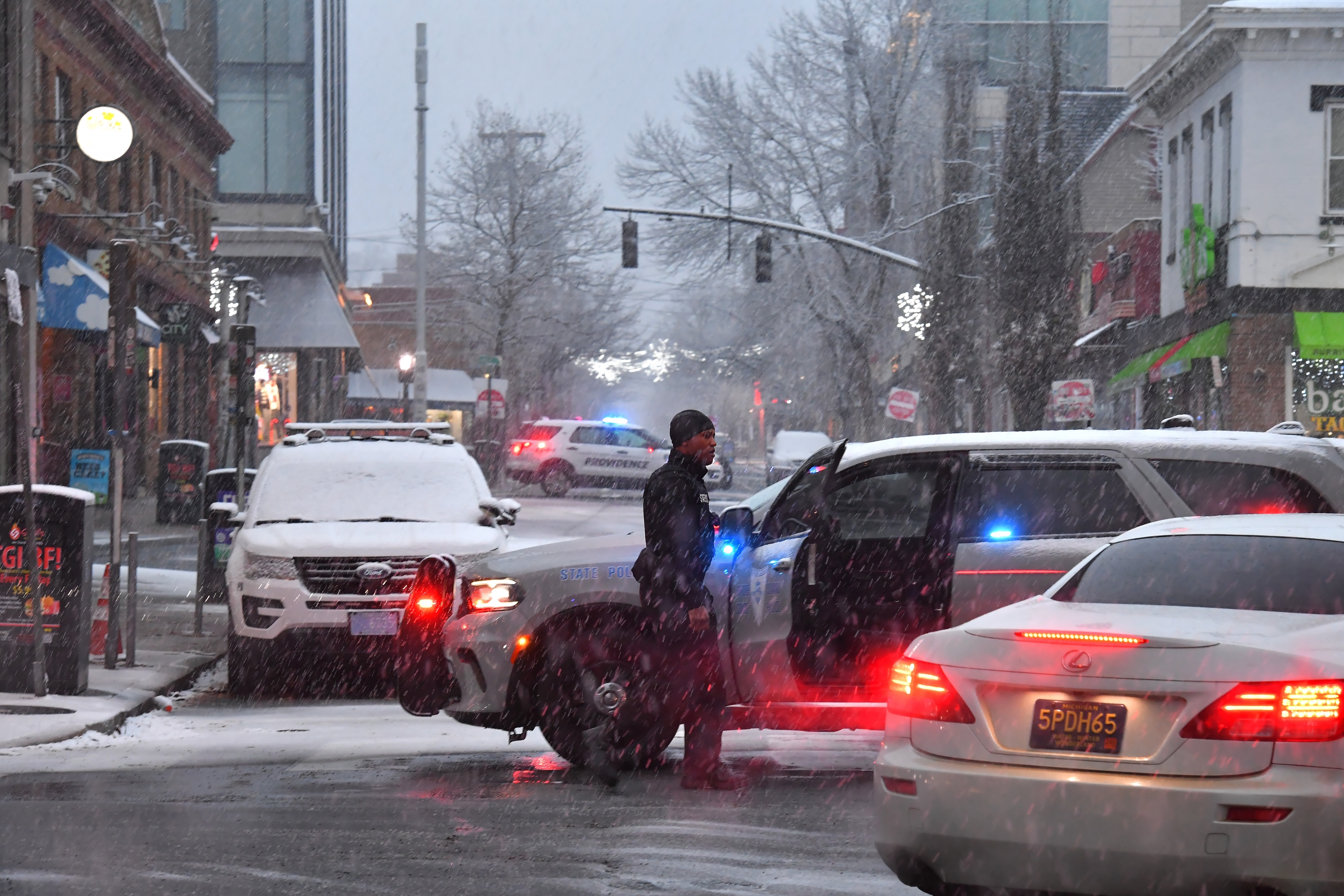 FILE - A law enforcement official directs traffic in a neighborhood near Brown University, Sunday, Dec. 14, 2025, in Providence, R.I., following a Saturday, Dec. 13, shooting at the university.