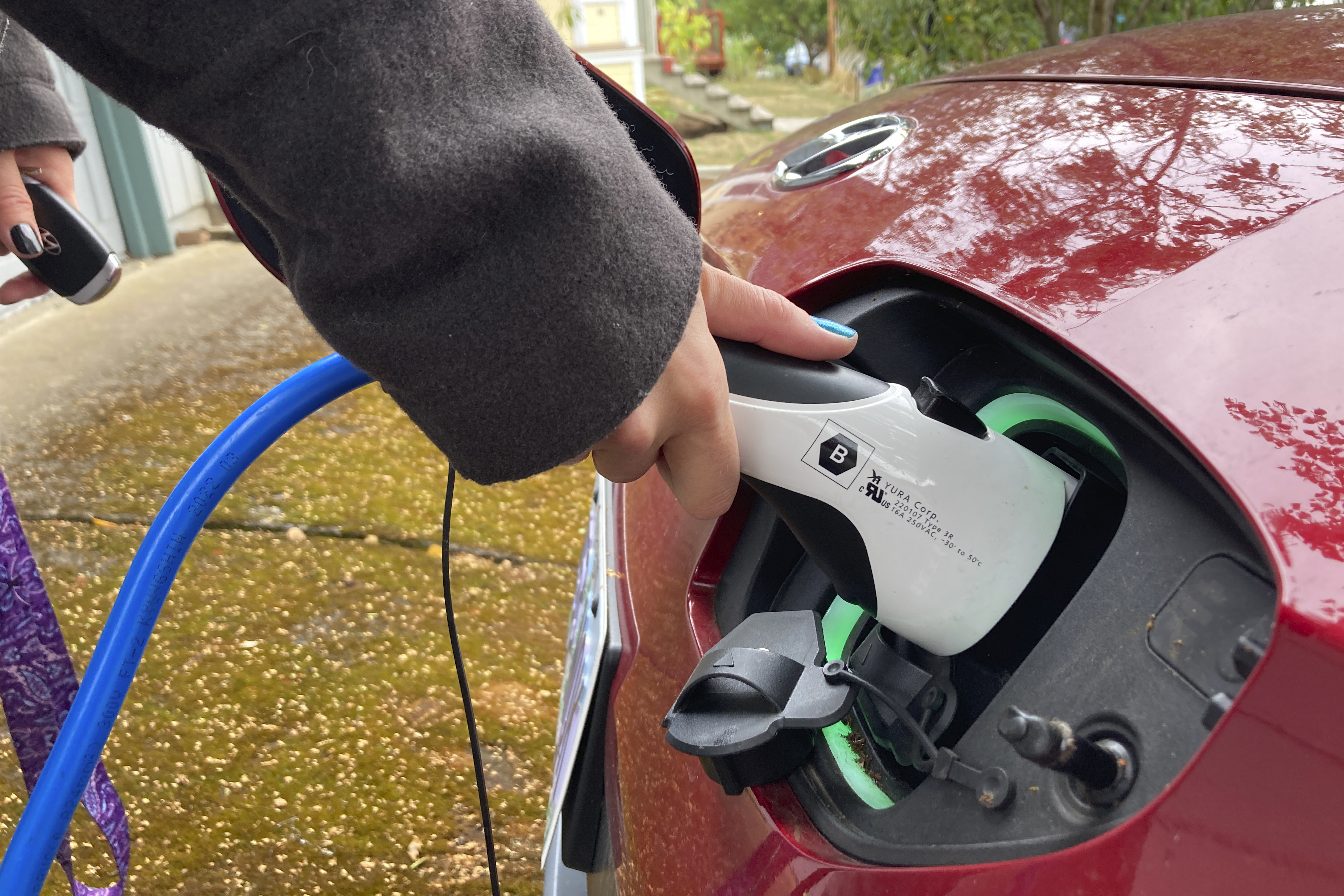 FILE - A driver charges her electric vehicle in the driveway of the Portland, Ore., home she rents on Sept. 30, 2022.