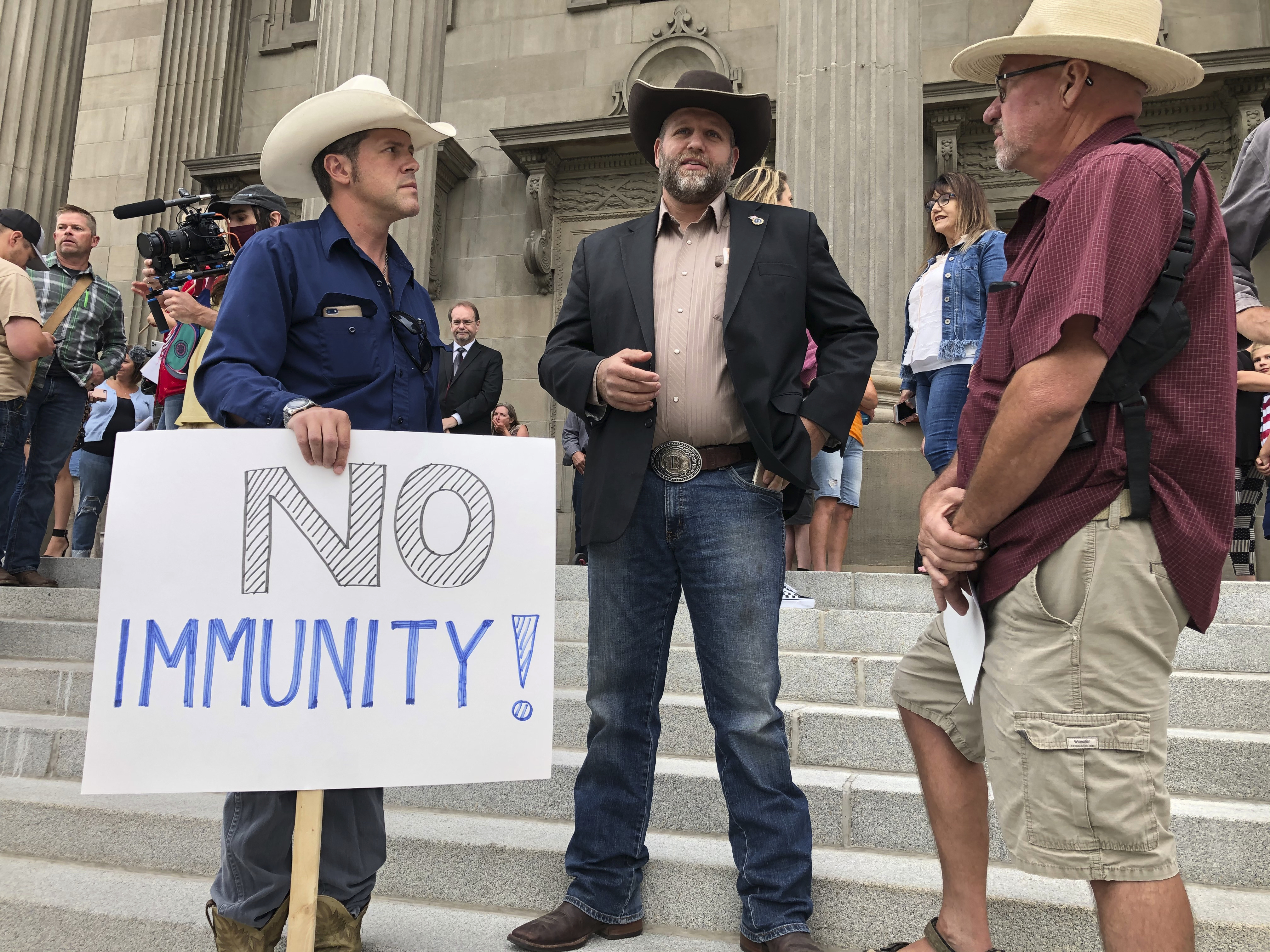 FILE - In this Aug. 24, 2020, file photo Ammon Bundy, center, who led the Malheur National Wildlife Refuge occupation, stands on the Idaho Statehouse steps in Boise, Idaho. A federal bankruptcy judge ruled that Bundy cannot discharge a $52 million civil judgment against him after defaming St. Luke's Health System. Bundy claimed the hospital trafficked and kidnapped children to make money. (AP Photo/Keith Ridler, File)