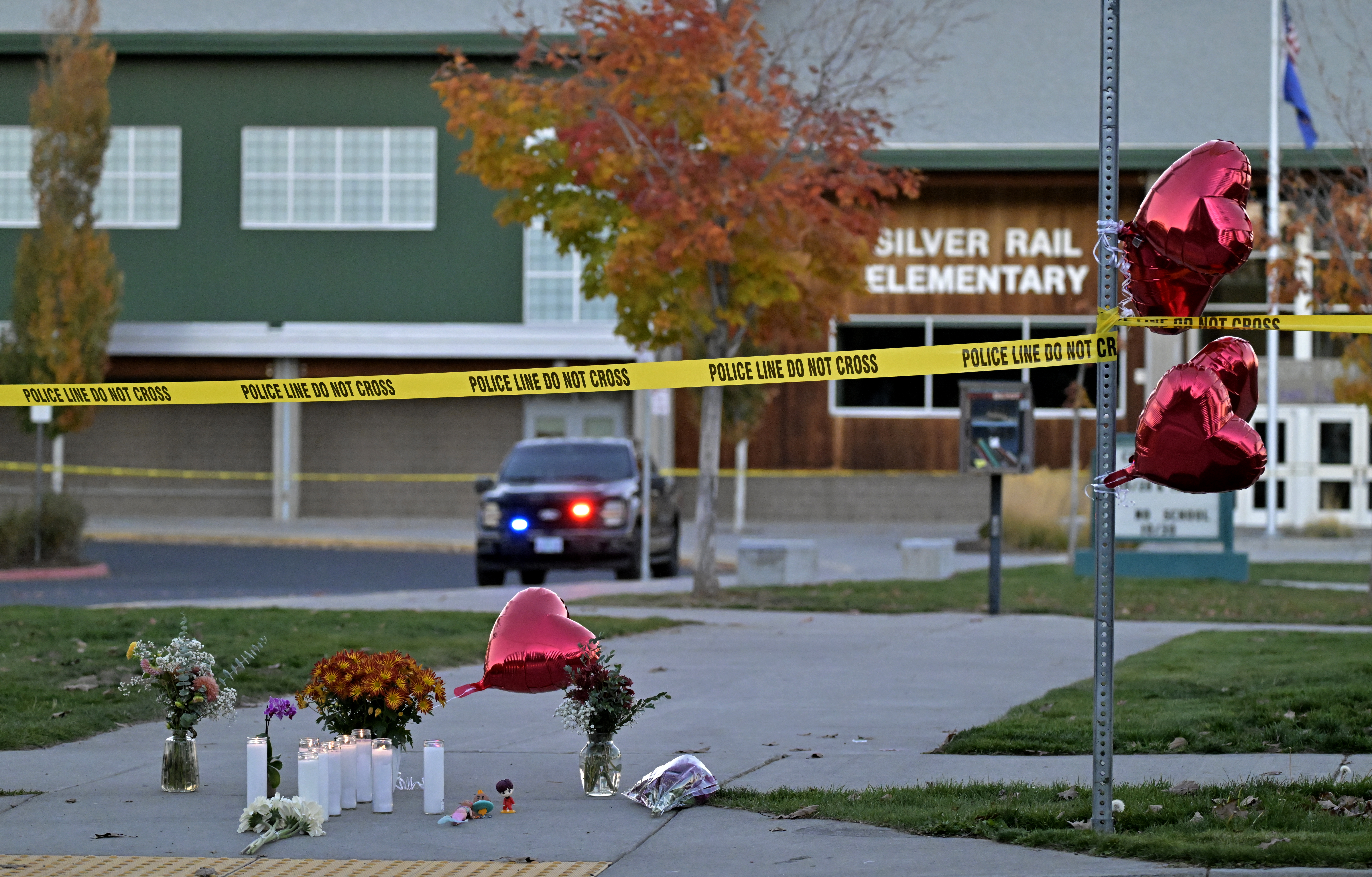 Items are left in front of Silver Rail Elementary School in Bend, Ore., Oct. 15, 2026, as the investigation continues at the scene. Sources have confirmed that three children and an adult died in the shooting. The suspected shooter also died at the scene.