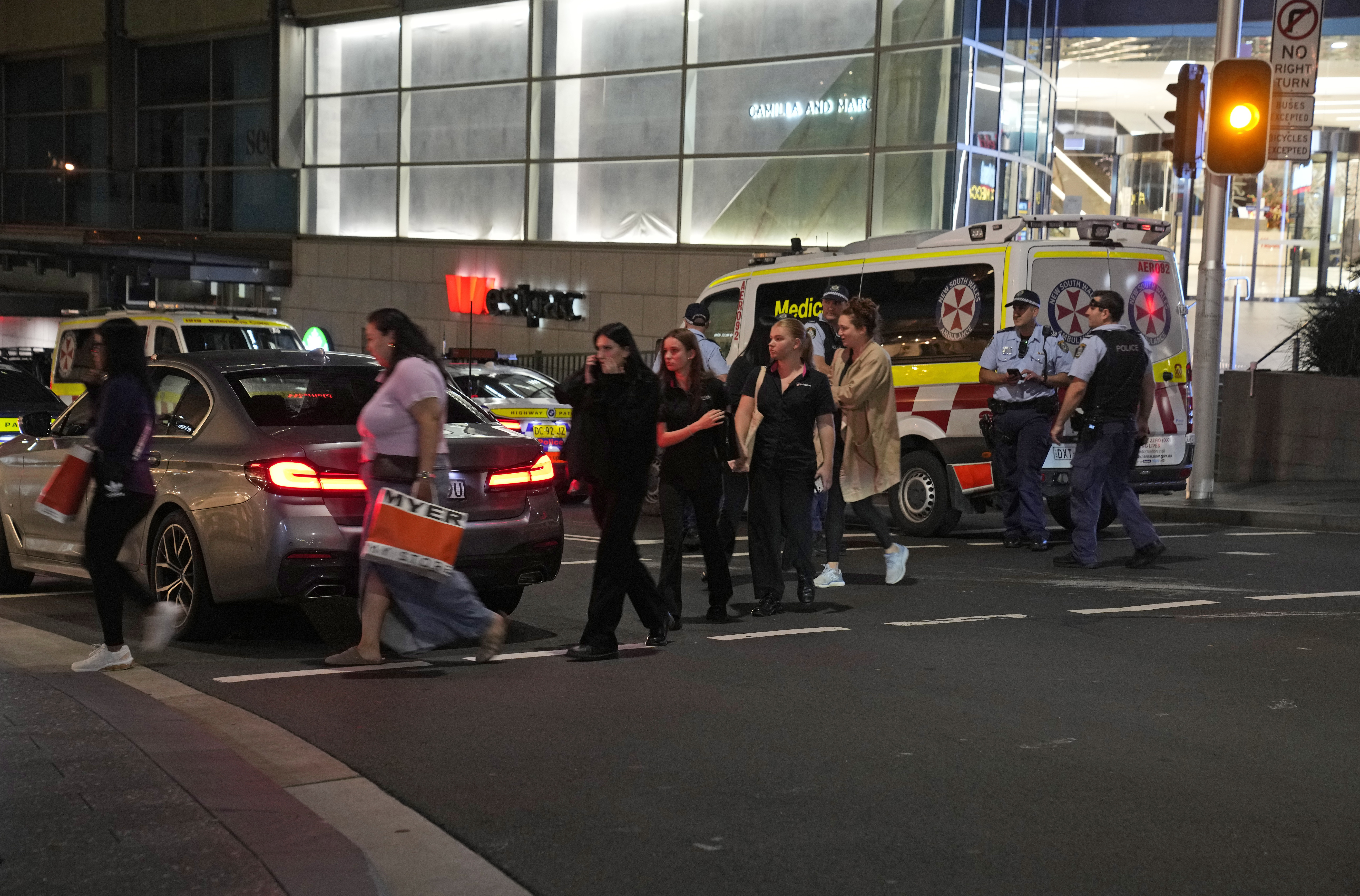 People are led out from the Westfield Shopping Centre where multiple people were stabbed in Sydney on Saturday.