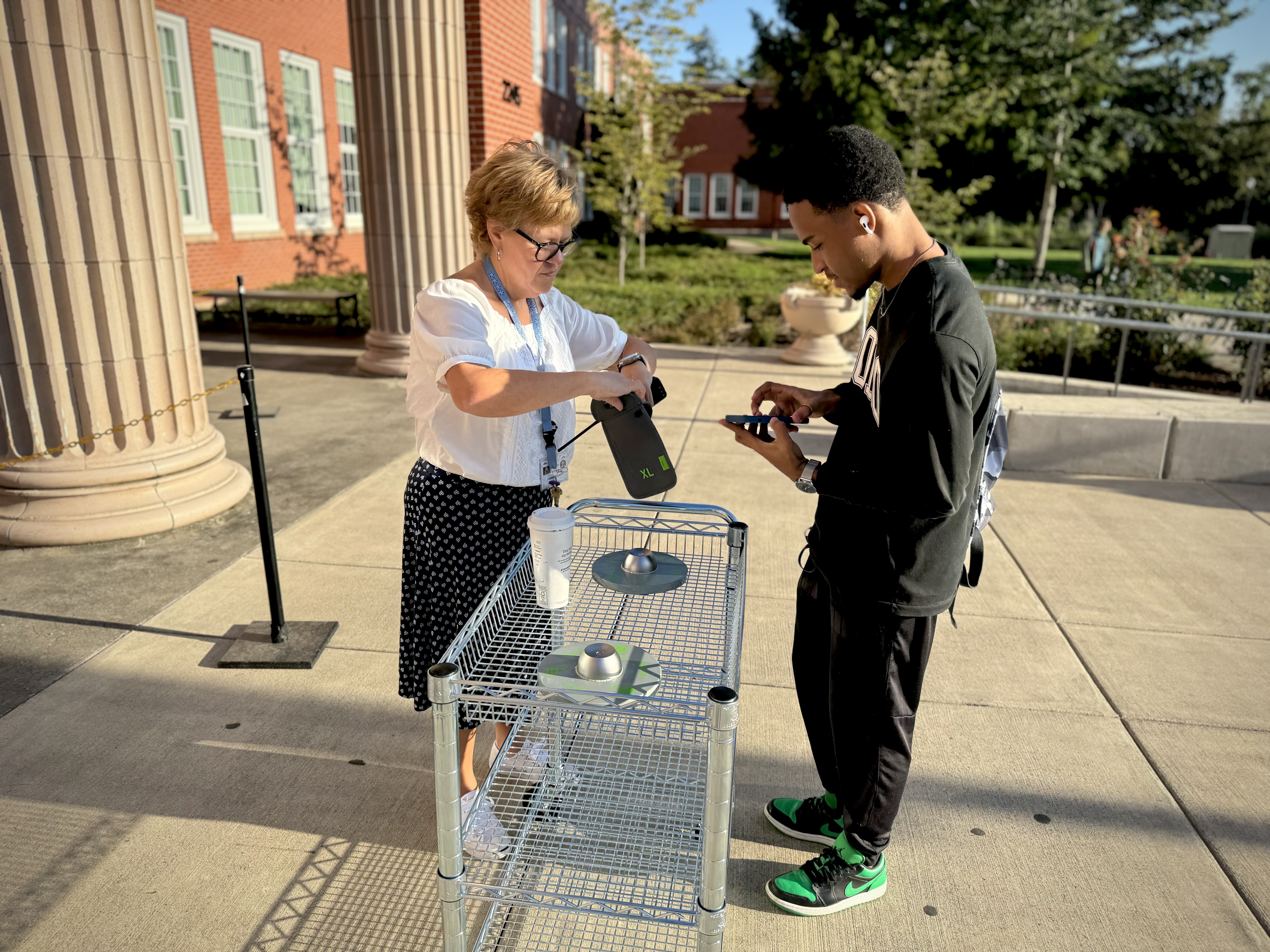 Vice Principal Jessika Magnett helps students with their Yondr cellphone pouches outside Grant High School in Portland on Wednesday, Aug. 28, 2024. ODE's guidance suggests that cellphone locking pouches cost an average of $27 per student per year, citing publicly available data and reports.