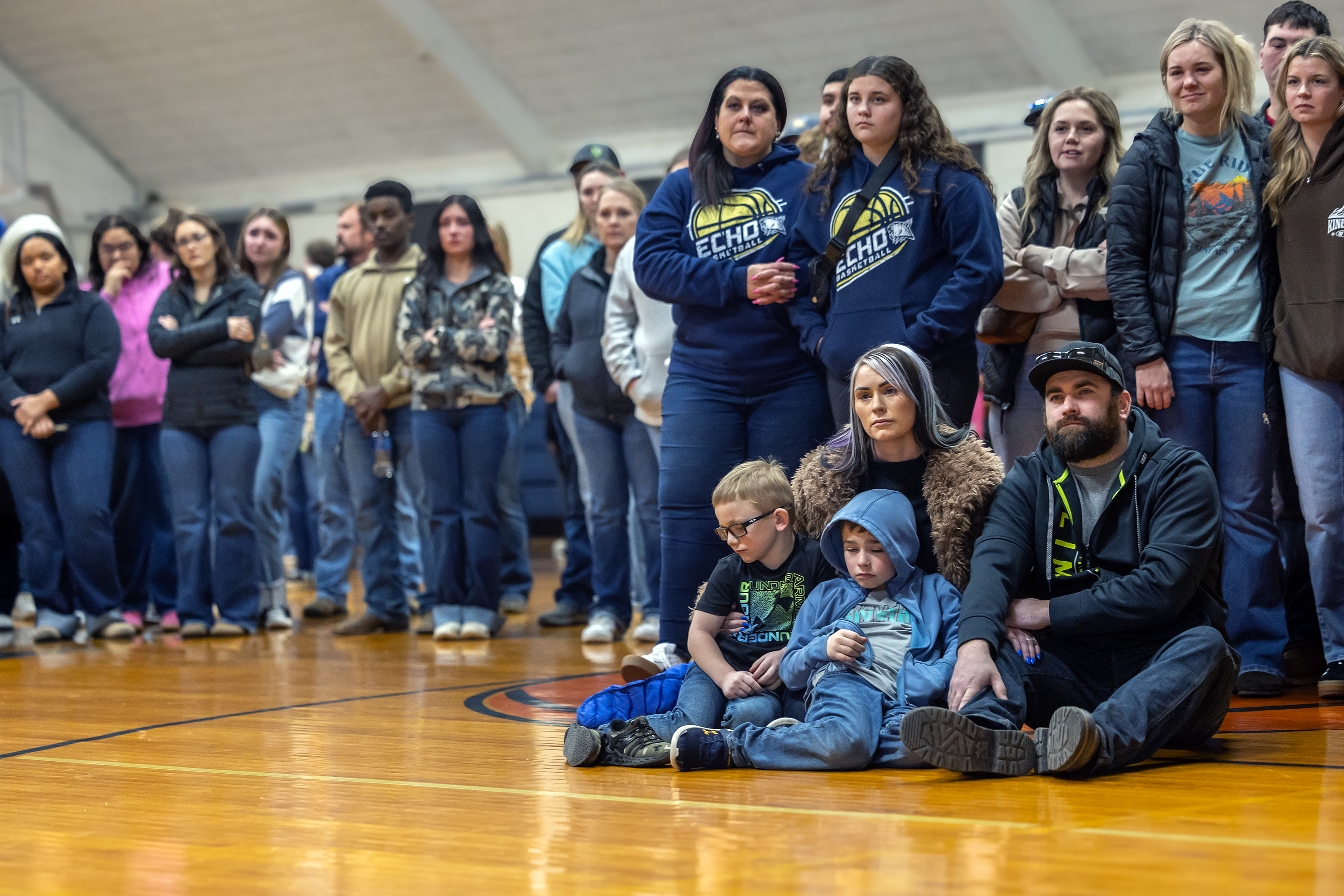 Community members watch a slide show and listen to music at a vigil for Arizona helicopter crash victims David McCarty and nieces Faith McCarty, Rachel McCarty and Katelyn Heideman in the Echo High School old gym on Jan. 9, 2026, in Echo, Ore.