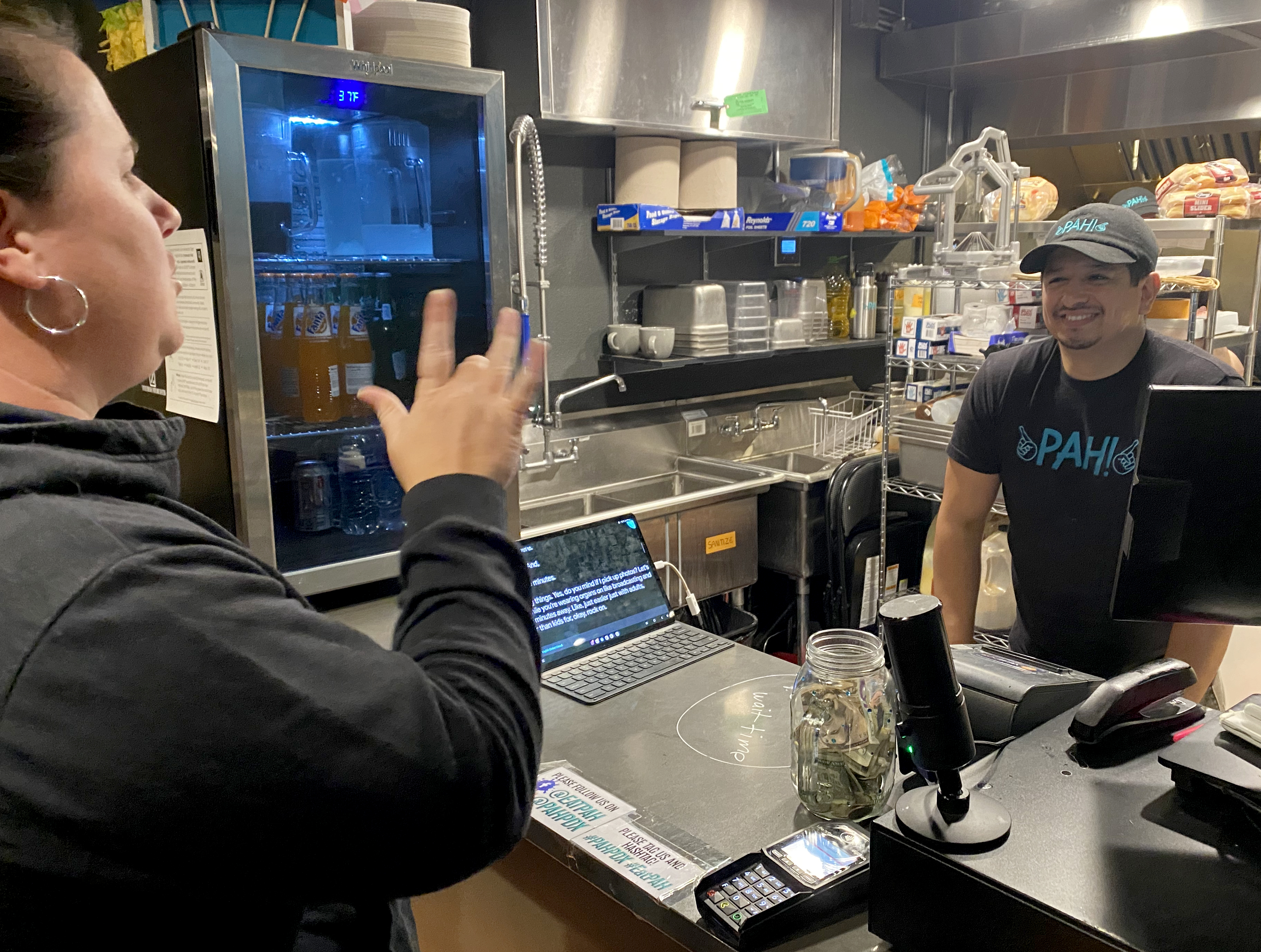 ASL teacher Sarah Caine orders dinner at Pah! restaurant from owner Lillouie Barrios. Located in The Zed in SE Portland,   the restaurant is proudly queer, Latinx, and deaf owned.