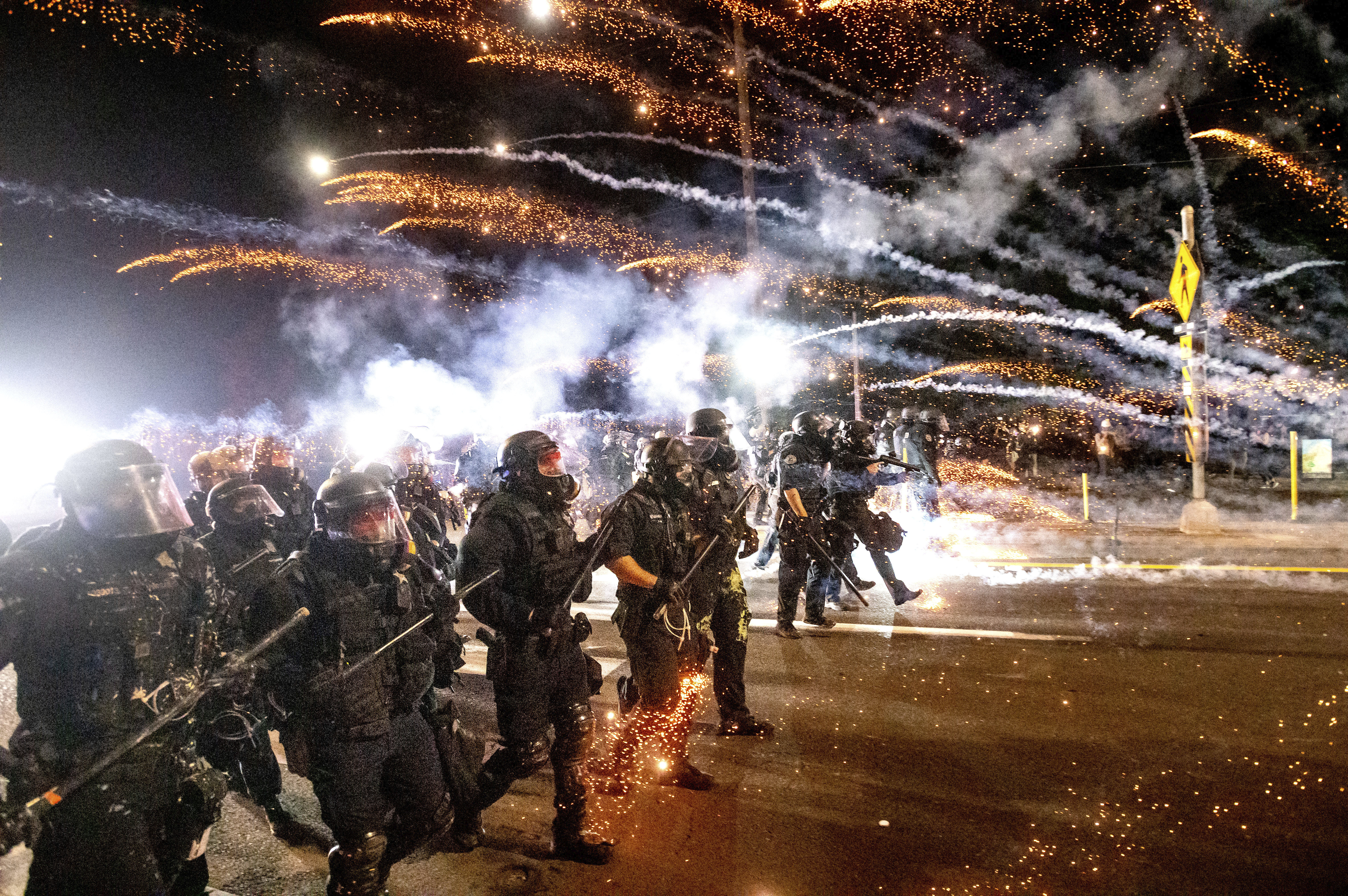 FILE - Police use chemical irritants and crowd control munitions to disperse protesters during a demonstration in Portland in 2020, on the 100th consecutive day of protests.