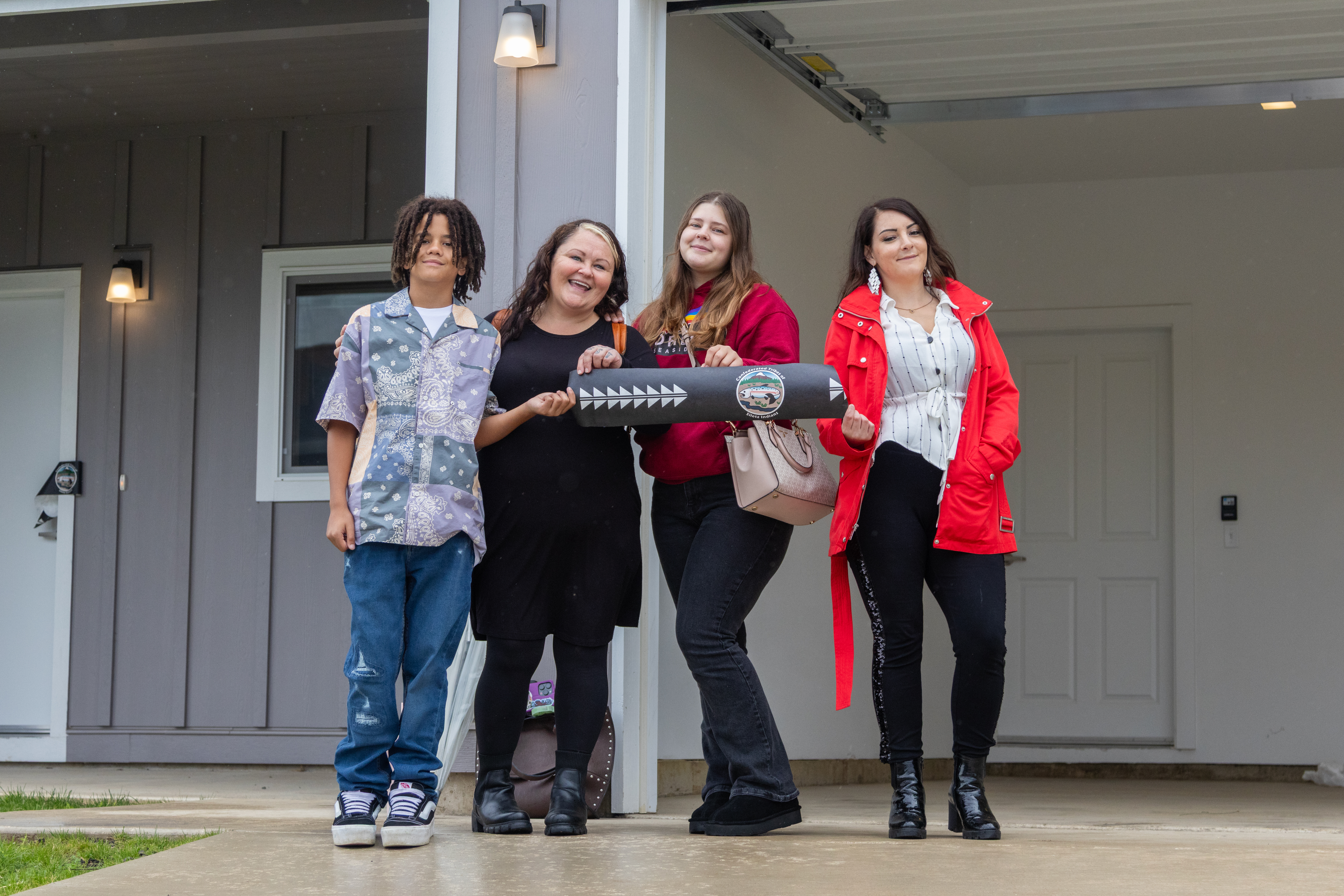 Vera Vasquez and her three children pose for their photo with two Confederated Tribes of Siletz Indians Housing employees while cutting through the ribbon on the front door of their new home on Sept. 29, 2025. Vasquez and other tenants are scheduled to start moving-in during the beginning of October.
