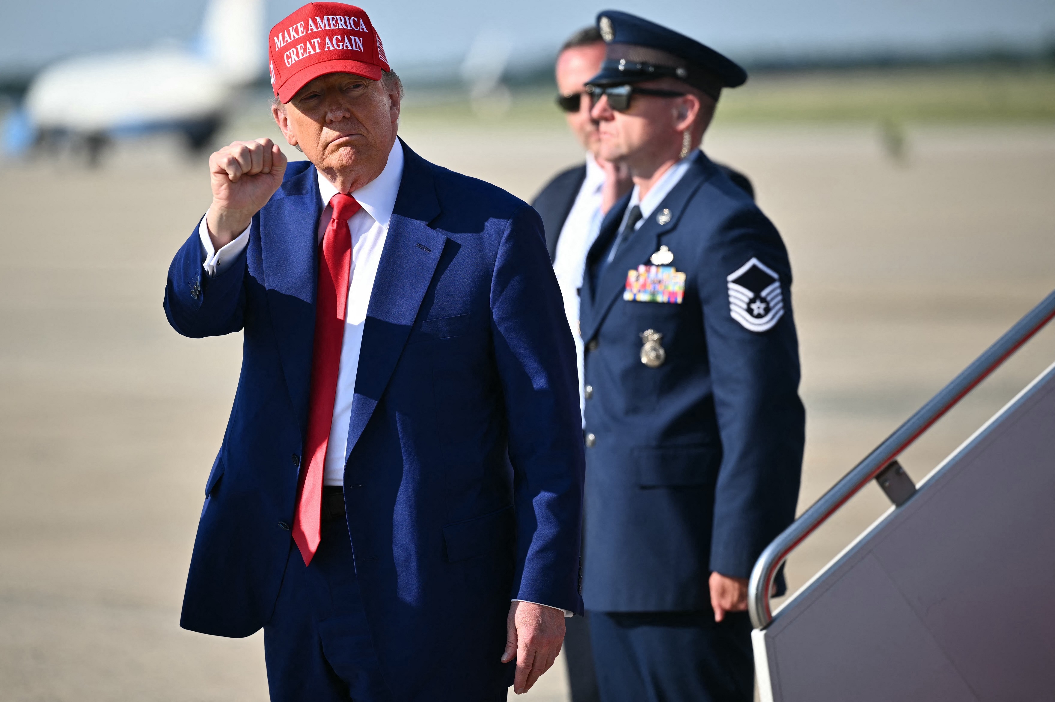 President Trump pumps his fist after stepping off Air Force One at Joint Base Andrews in Maryland on Saturday.