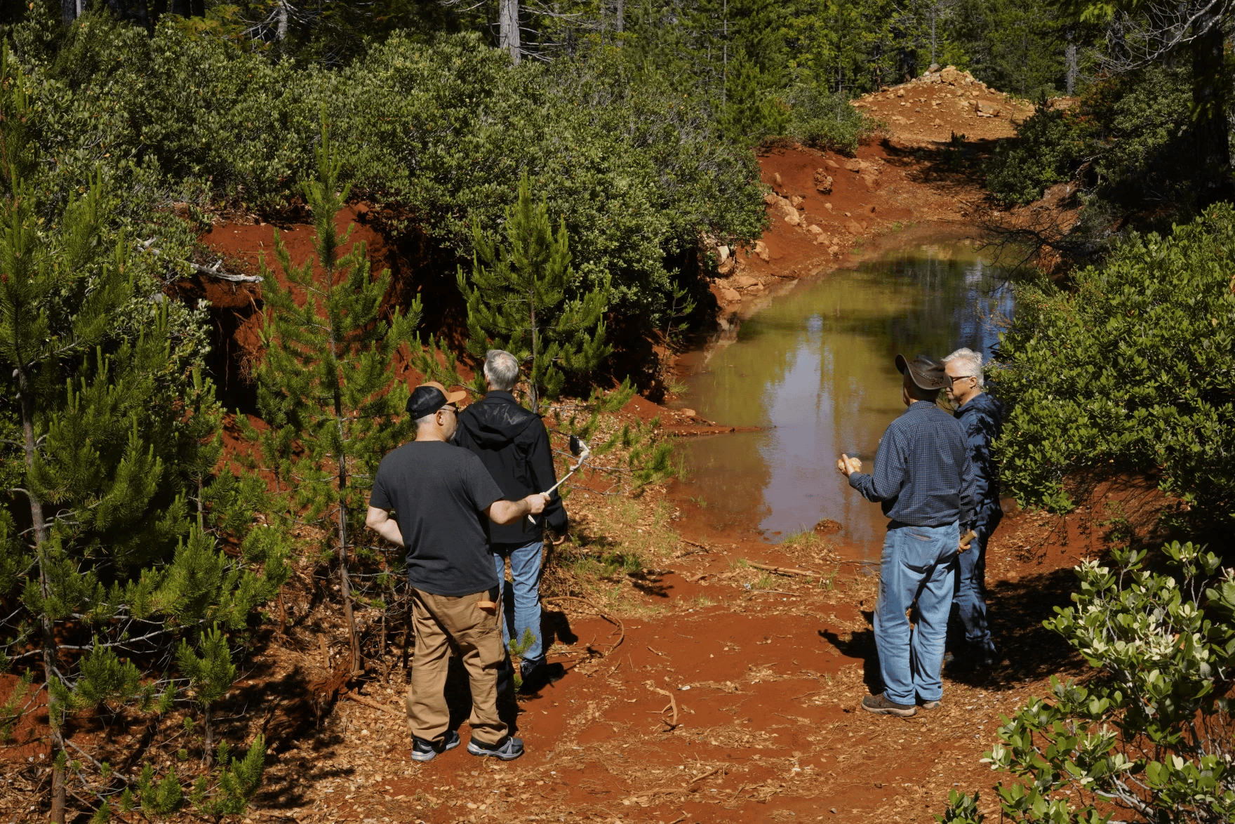 A Homeland Nickel team stands near a trench dug by a previous mining company at their Red Flat claim in Curry County in June of 2026.