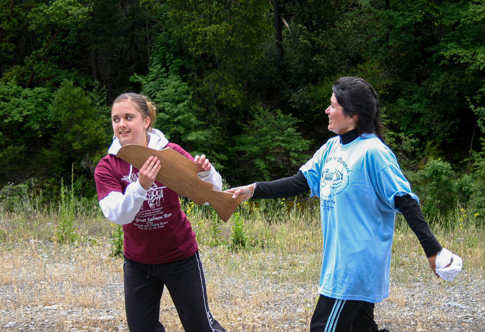 Runners take turns passing carved wooden salmon batons to the next person as they complete their portion of the race.