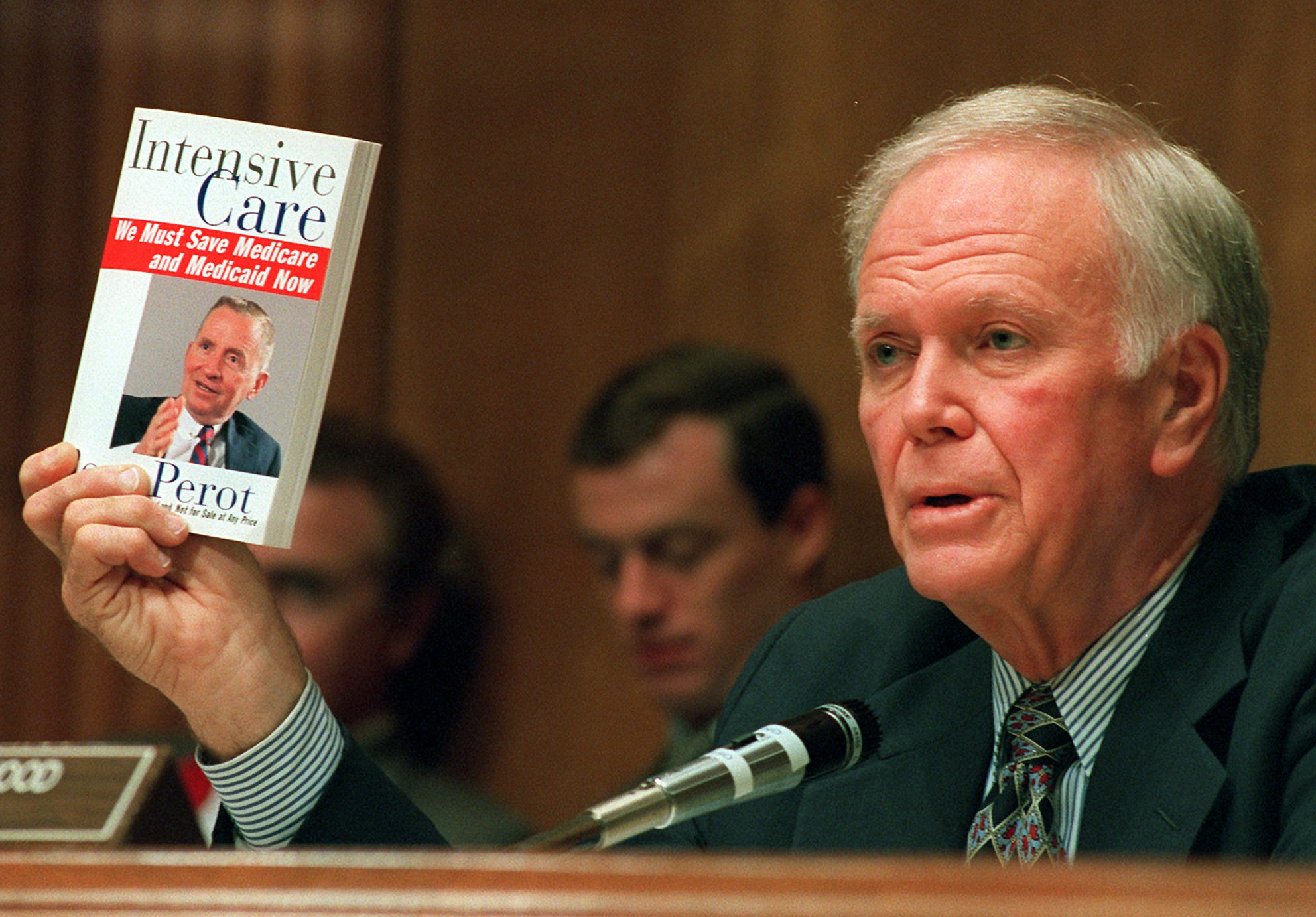 Senate Finance Committee Chairman Bob Packwood, Oregon, holds a book entitled "Intensive Care" by Ross Perot during hearings dealing with the future of Medicare on Capitol Hill Wednesday, Aug. 30, 1995.