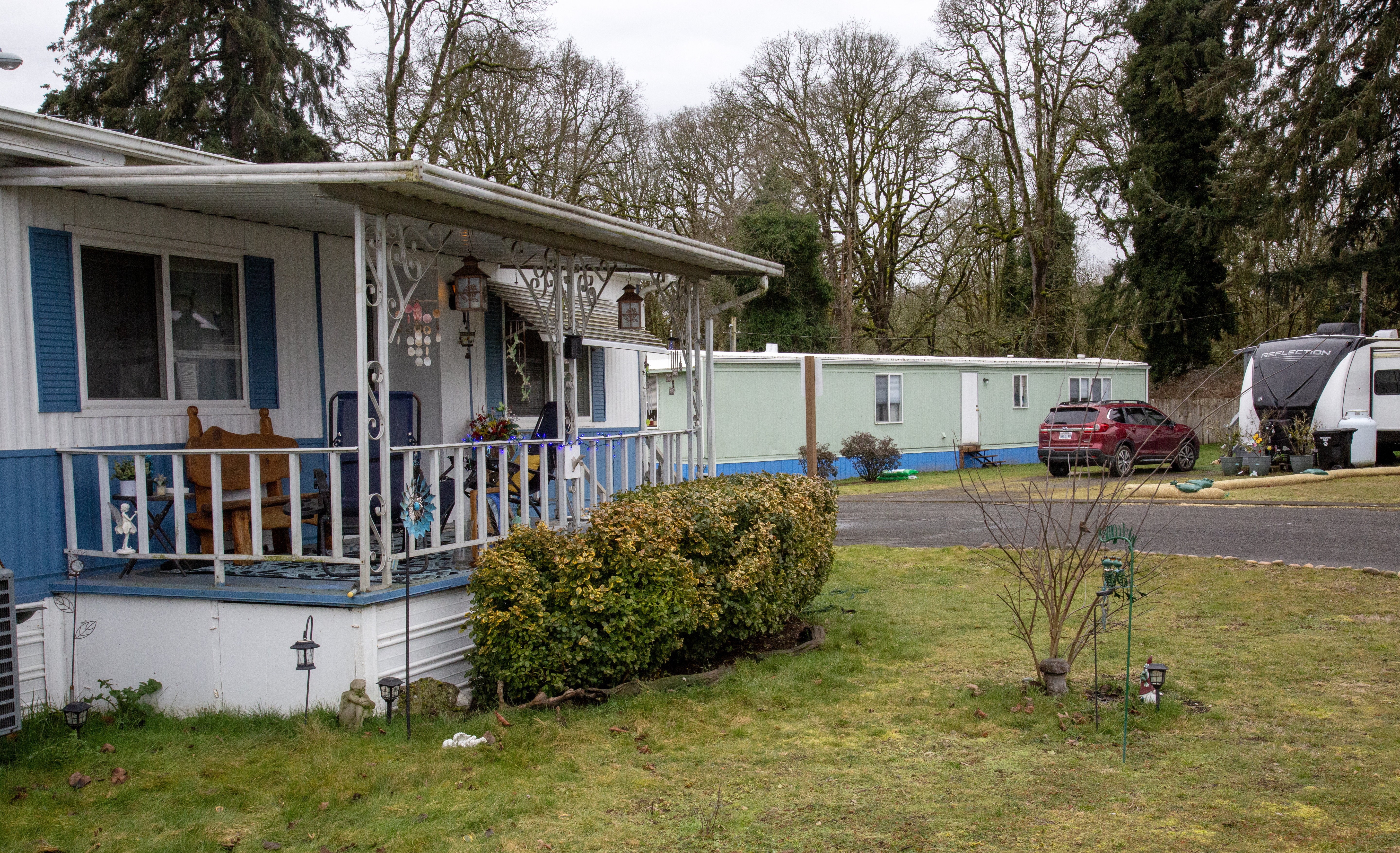 The exterior of a mobile home with a grassy lawn in front.