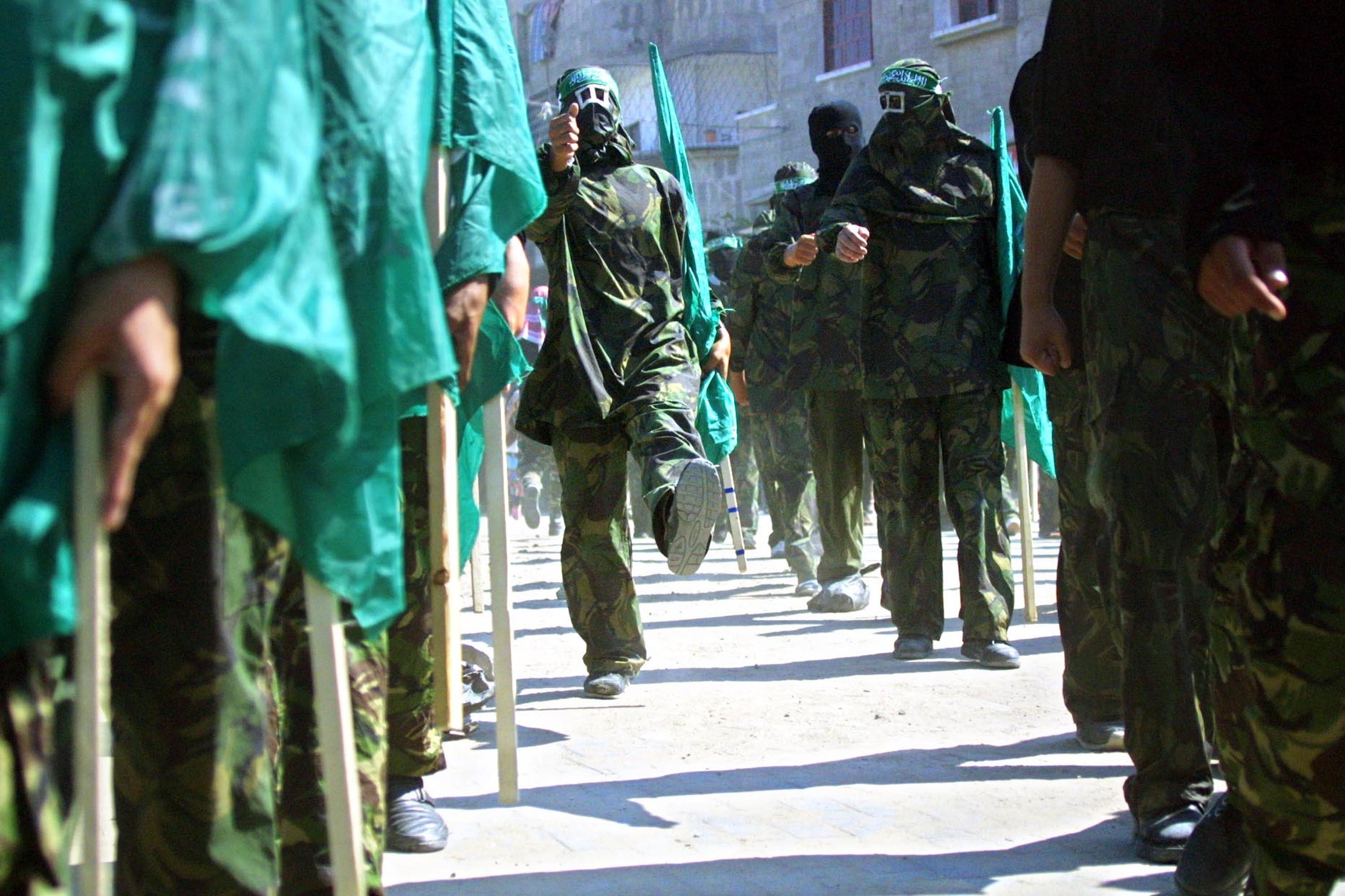 Masked members of Hamas hold Islamic flags during a march in the Jabalia refugee camp in the Gaza Strip to protest against the U.S. position on Jerusalem, Oct. 4, 2002.