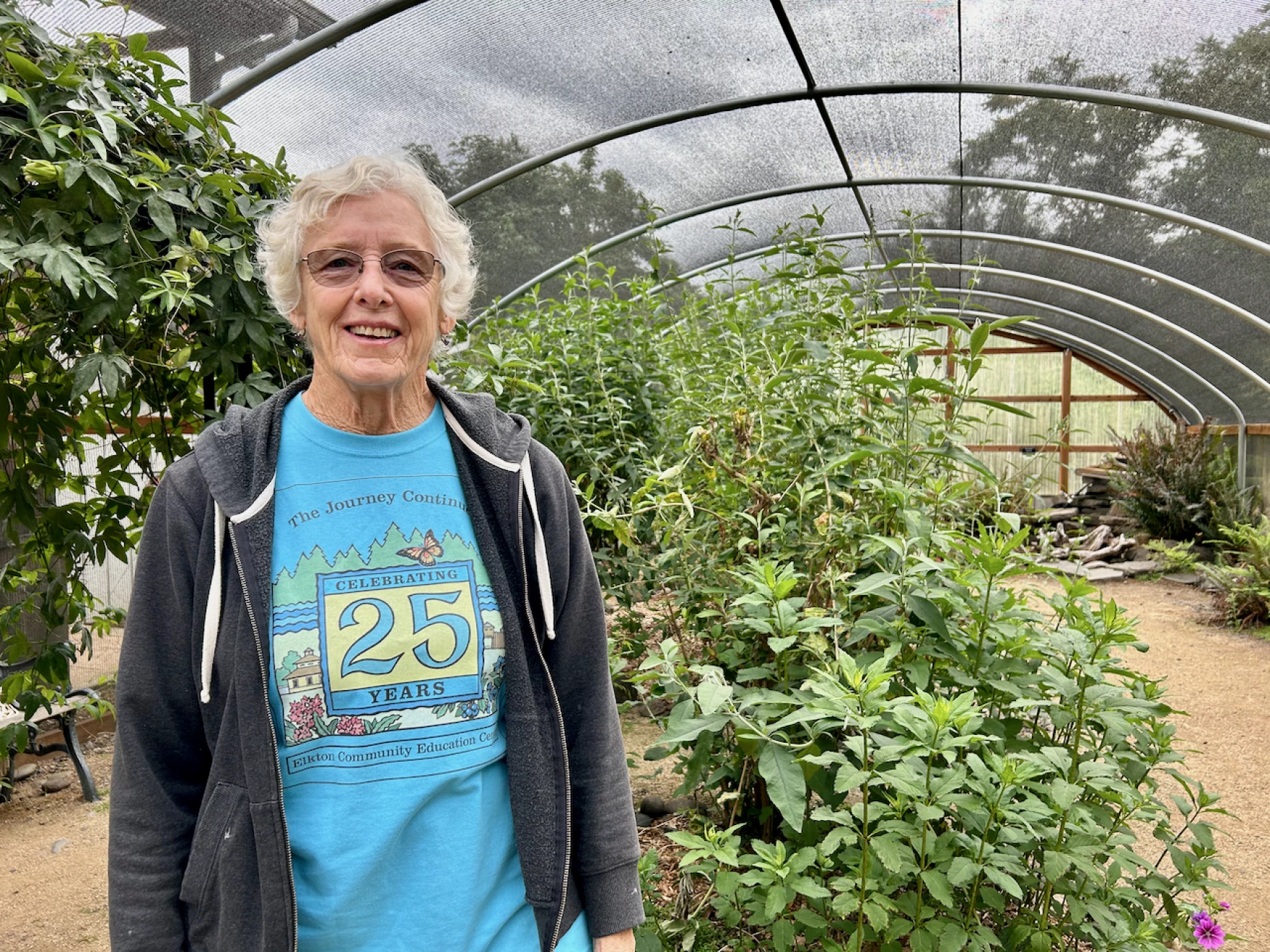 Barbara Slott stands near some flowering plants that will provide nectar for monarch butterflies.