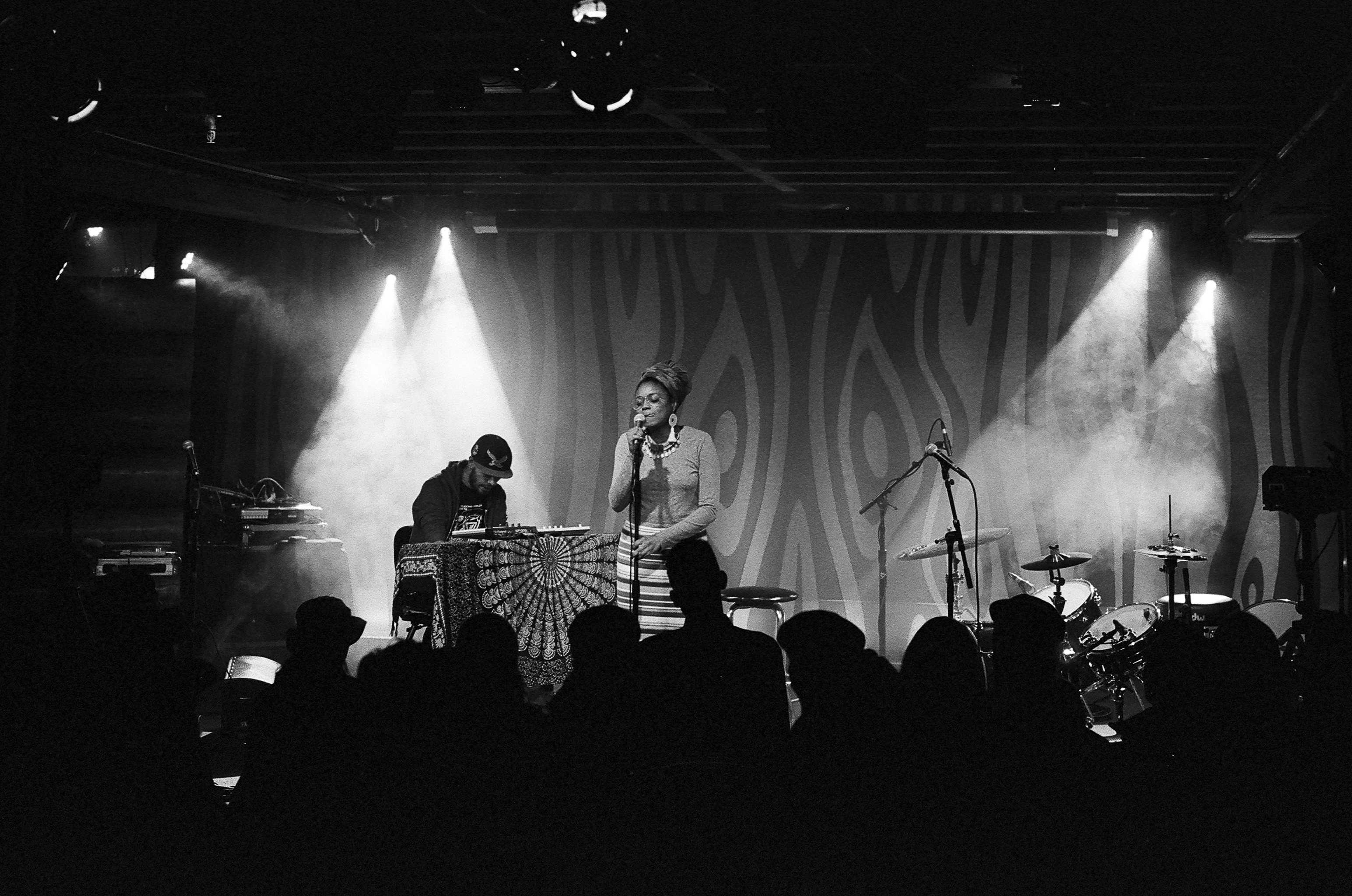A black and white photo of the duo Brown Calculus performing to a sold out crowd.