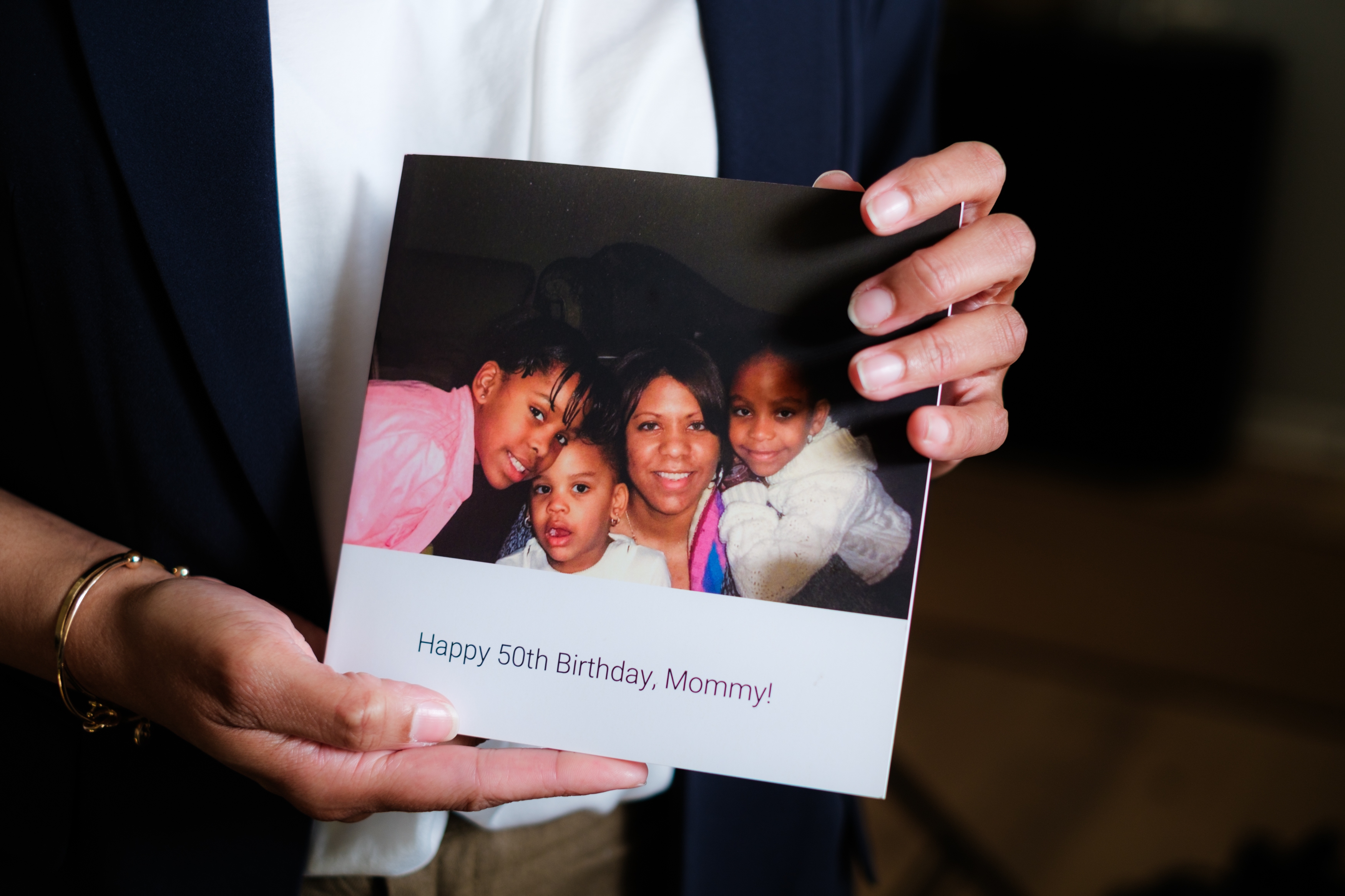 Knightdale, N.C. - March 26th, 2025: Candace Williams, a chief diversity officer who recently lost her job amid corporate America’s DEI retreats, holds a booklet she recieved from her daughters at her 50th birthday party. (Cornell Watson for NPR)