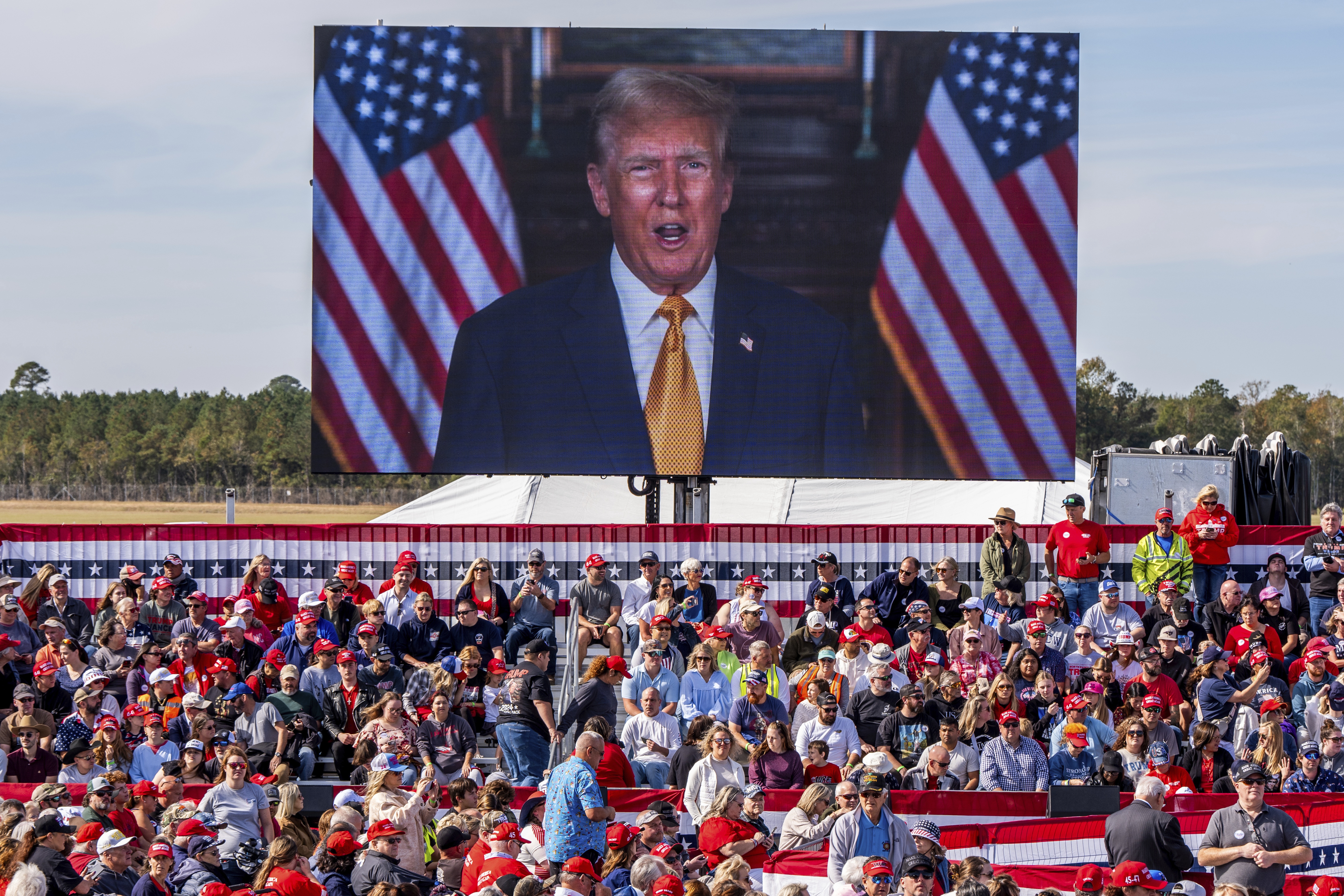 A video plays as supporters arrives to hear former President Donald Trump speak at a campaign rally at Kinston Jet Center on Nov. 3, 2024, in Kinston, N.C.