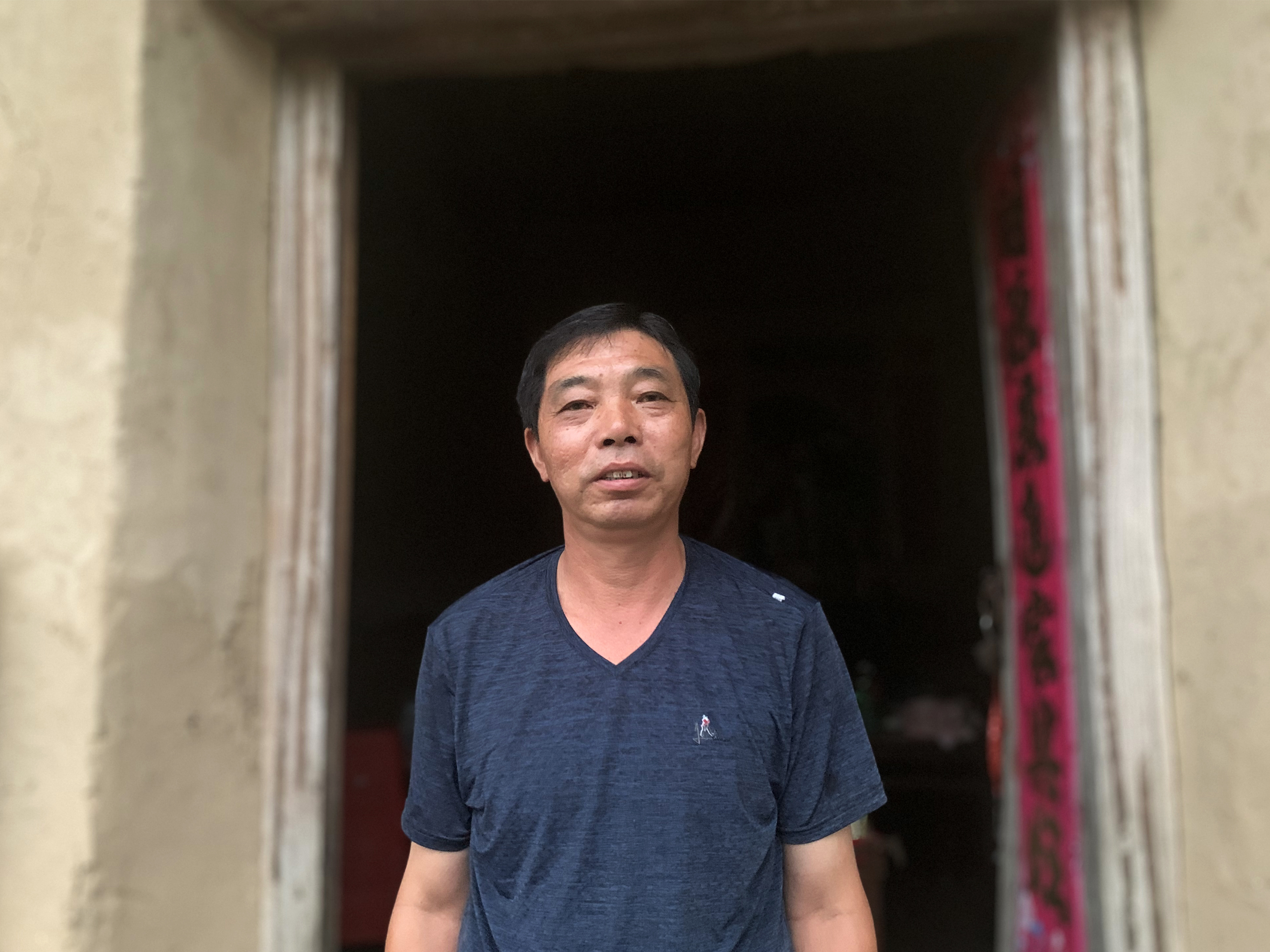 Zeng Hailin stands in front of his dilapidated home. During flash flooding in his Anhui village last month, he evacuated his 80-year-old mother by floating her out in a plastic washbasin.