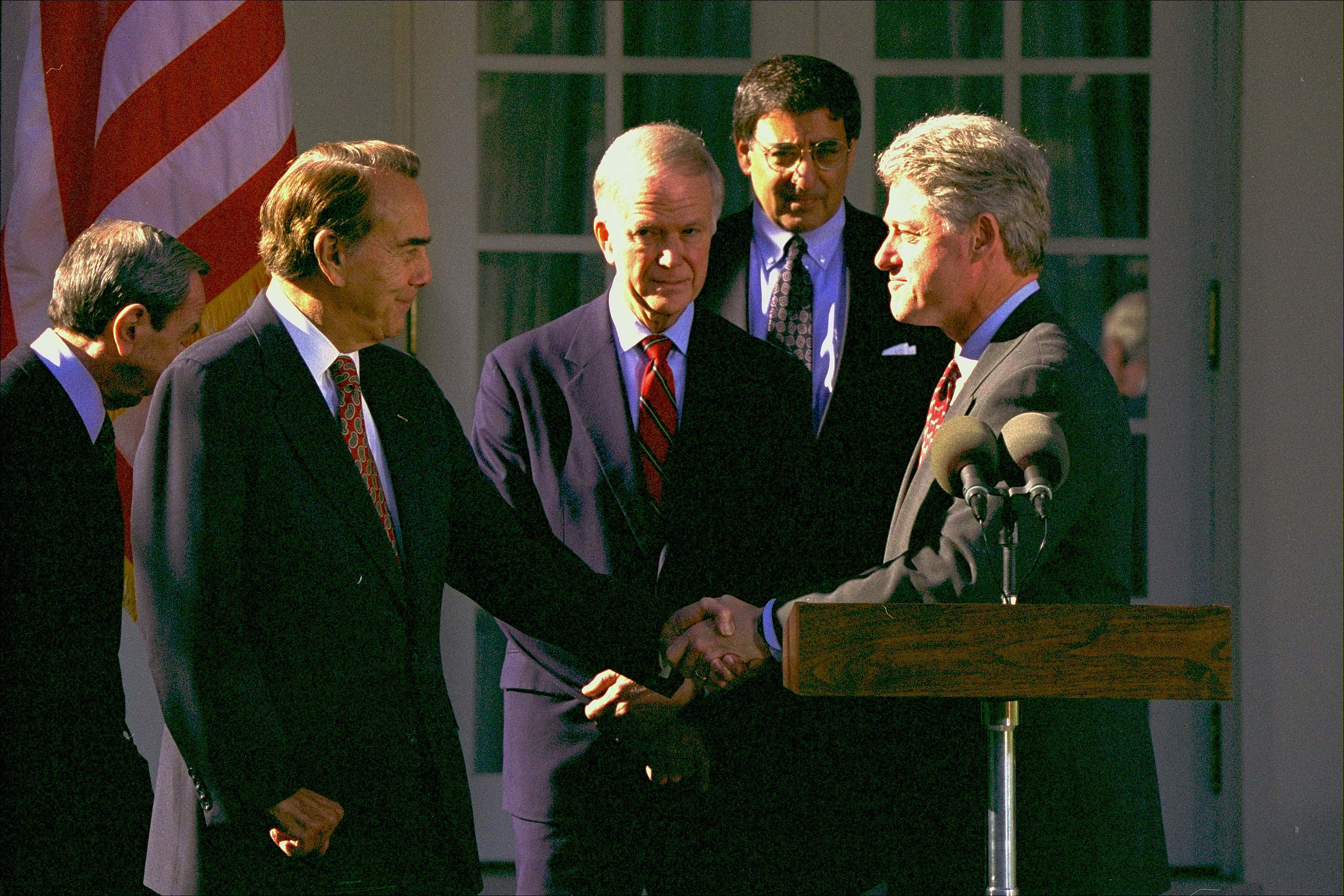 President Clinton shakes hands with Senate Majority Leader-in-waiting Bob Dole of Kansas in the Rose Garden of the White House, Wednesday November 23, 1994, where Dole delivered his support for the General Agreement on Tariffs and Trade(GATT). Sen. Bob Packwood, R-Ore., second from left, and White House Chief of Staff Leon Panetta, second from right, look on.