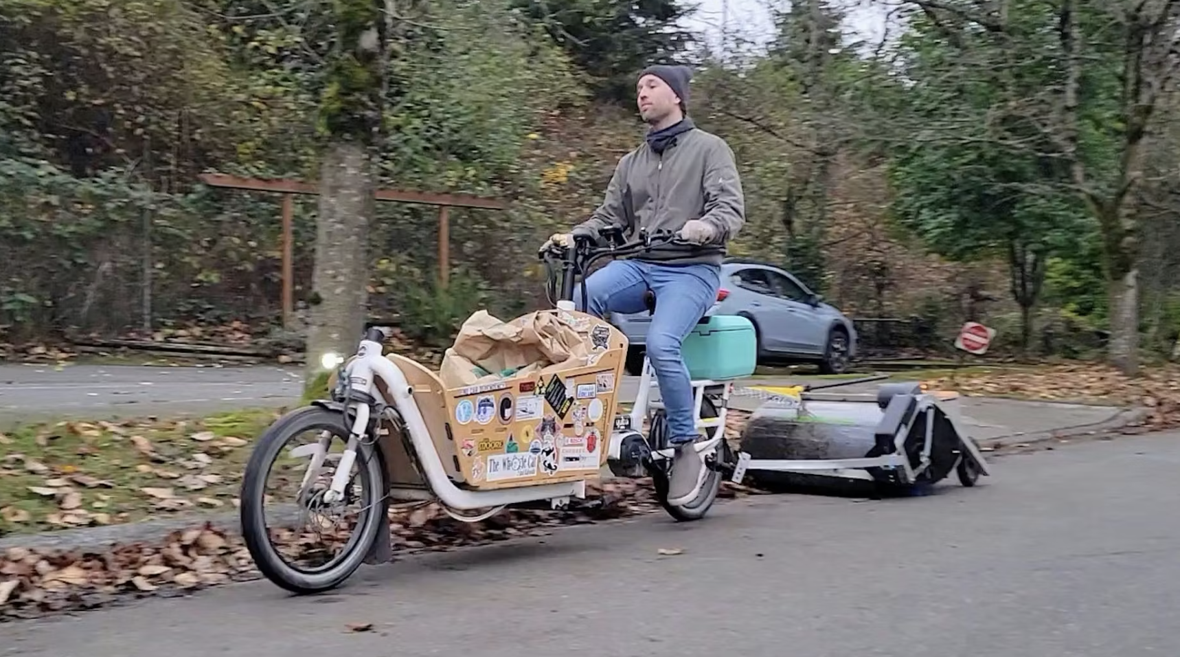 Charlie Liban pulls a bike-lane sweeper behind his e-bike in Kirkland, Wash., on Friday, Nov. 21, 2025.