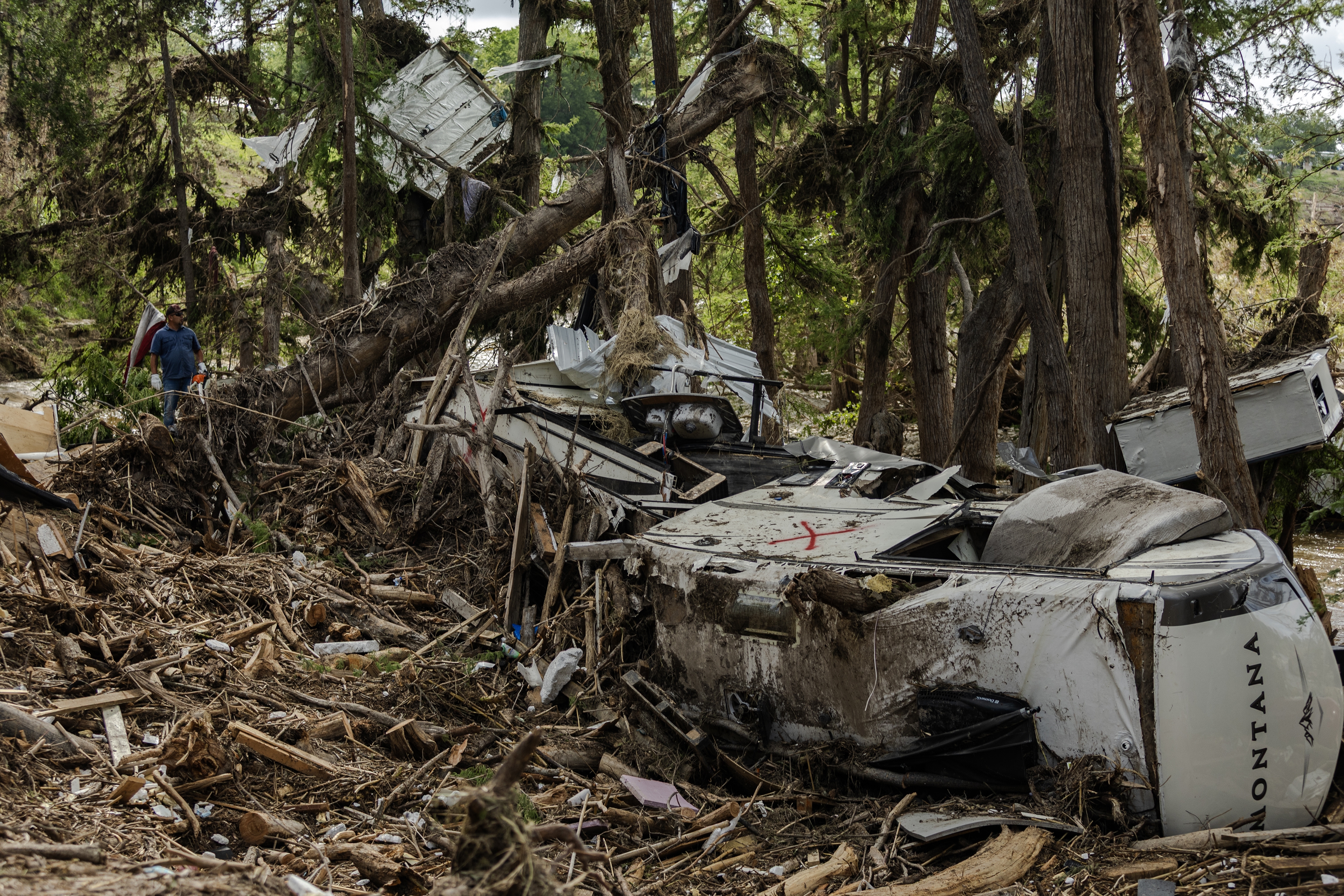 Search and recovery crews remove debris from the bank of the Guadalupe River on July 9, 2025 in Center Point, Texas, after deadly flash floods. 