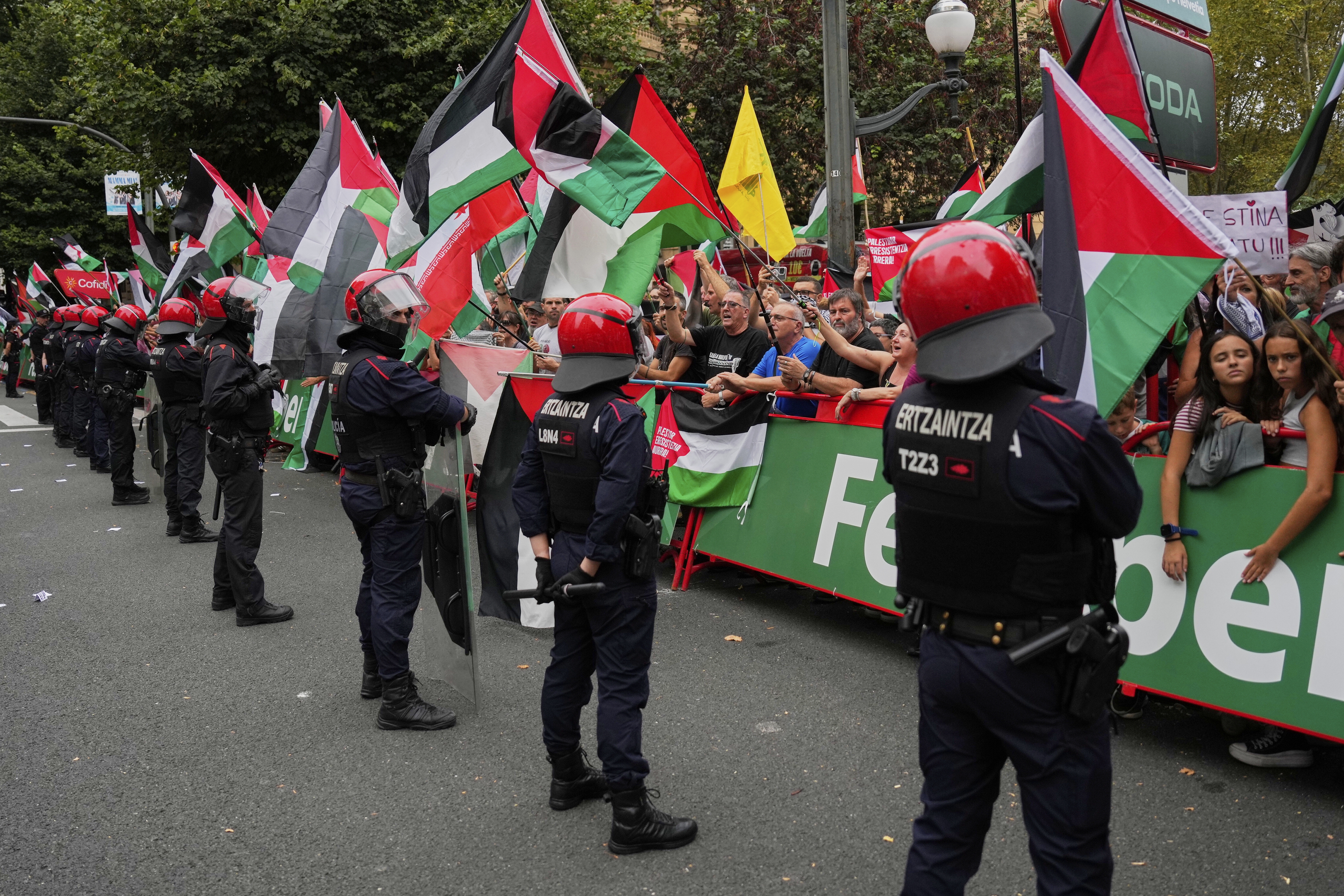 People hold Palestinian flags during the eleventh stage of the Spanish Vuelta cycling race, from Bilbao to Bilbao, Spain, Wednesday, Sept. 3, 2025.