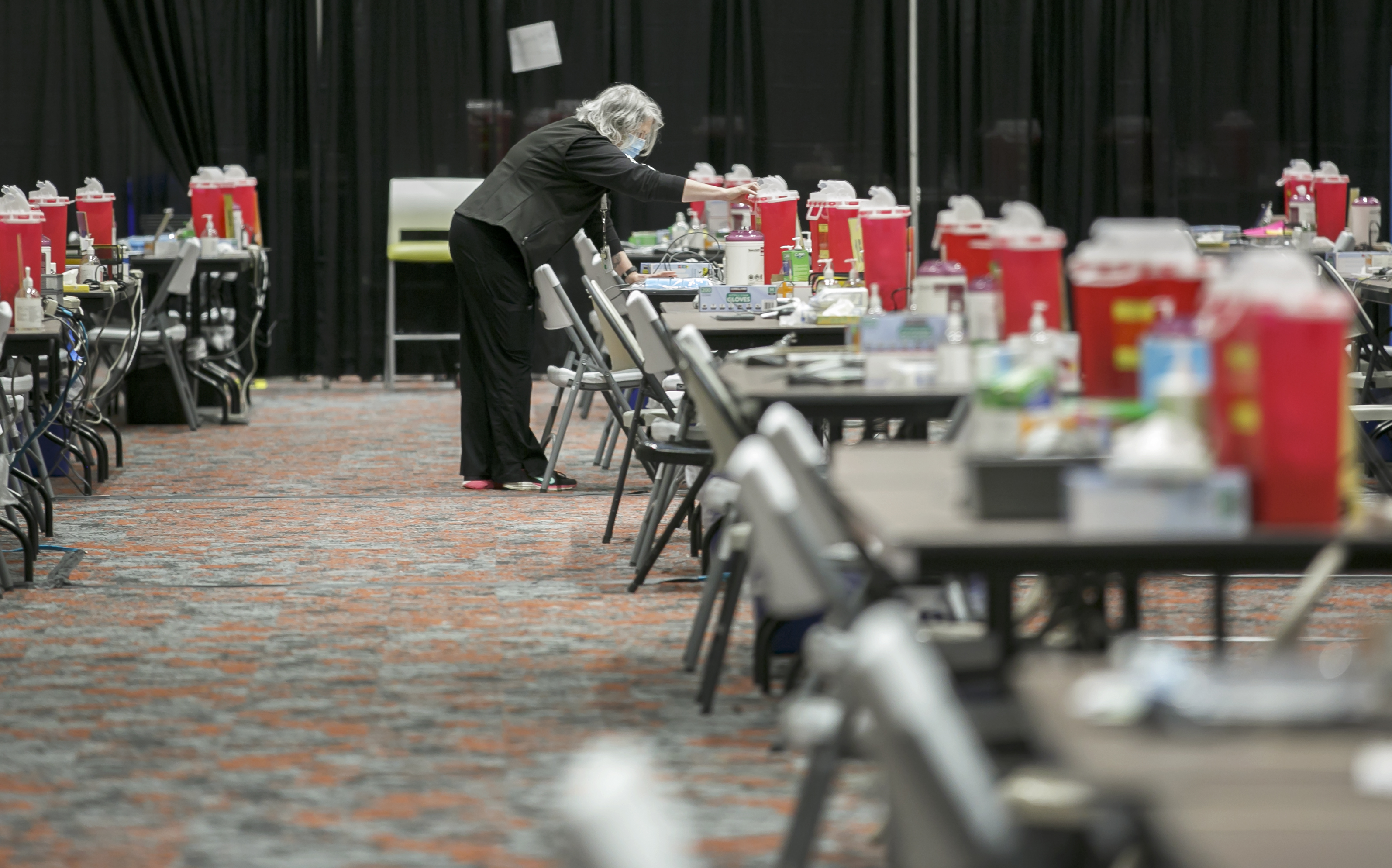 Kathy Swanson-Clark, a registered nurse, organizes the vaccination stations before the opening of the COVID-19 vaccination clinic  at the Oregon Convention Center in January. The clinic has delivered more than 400,000 shots and could close in mid June. 